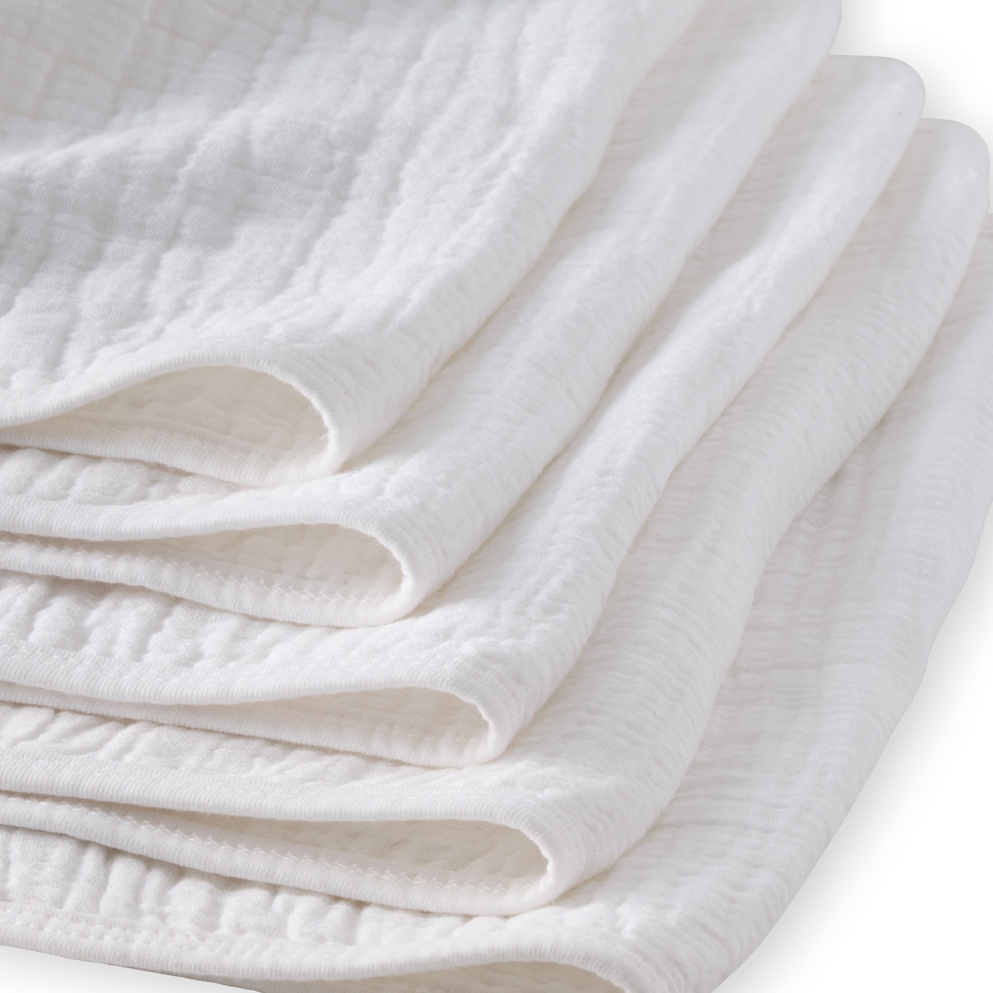 Folded white quilt on a light background