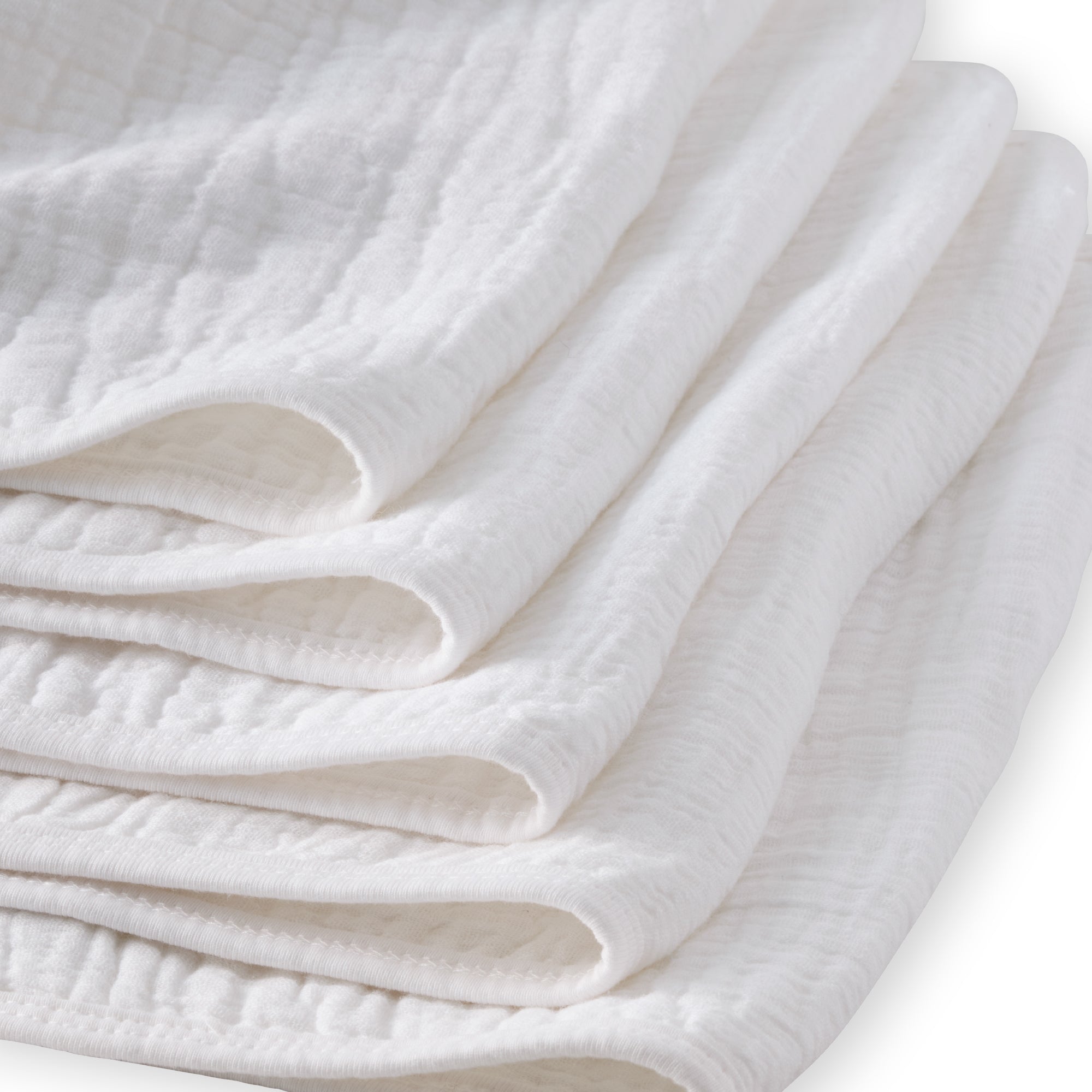 Folded white quilt on a light background