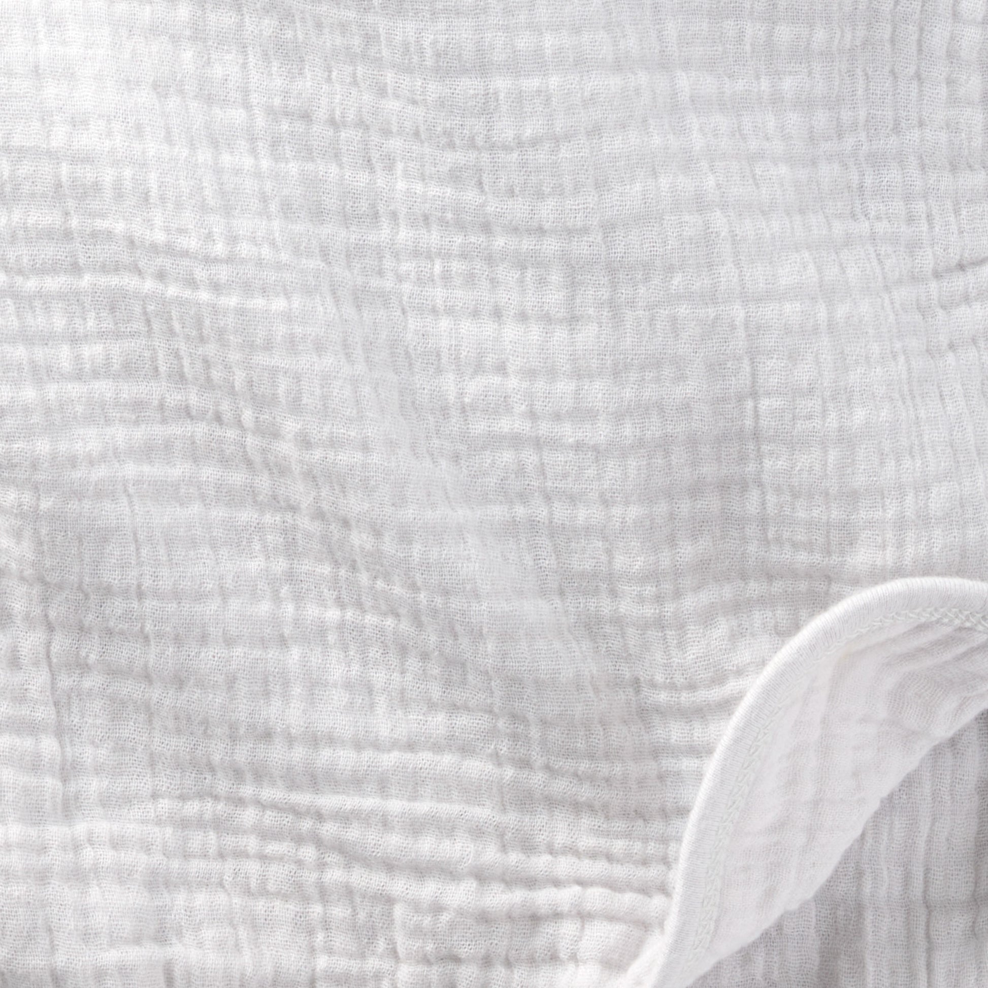 Close-up of textured white fabric with a slight sheen