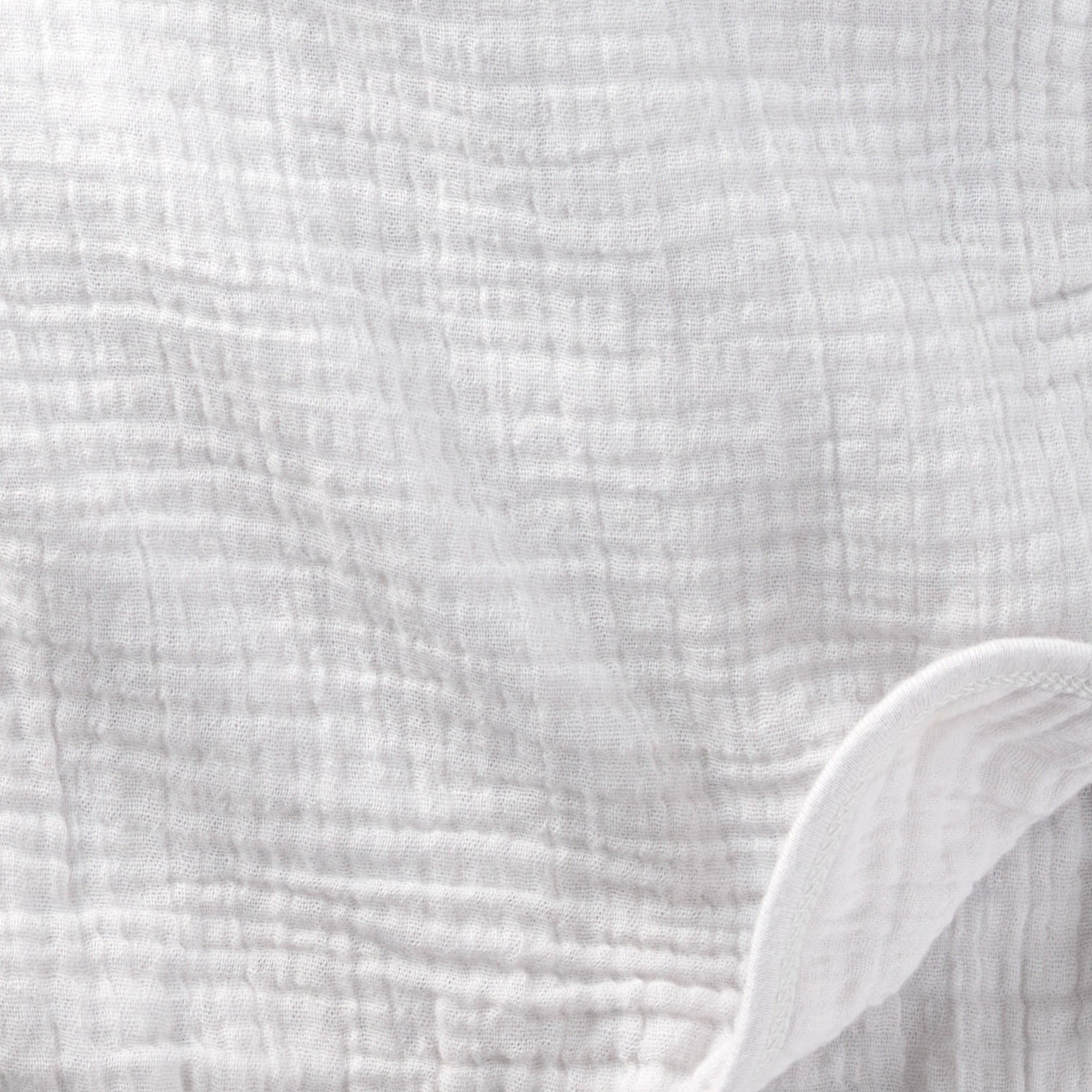 Close-up of textured white fabric with a slight sheen