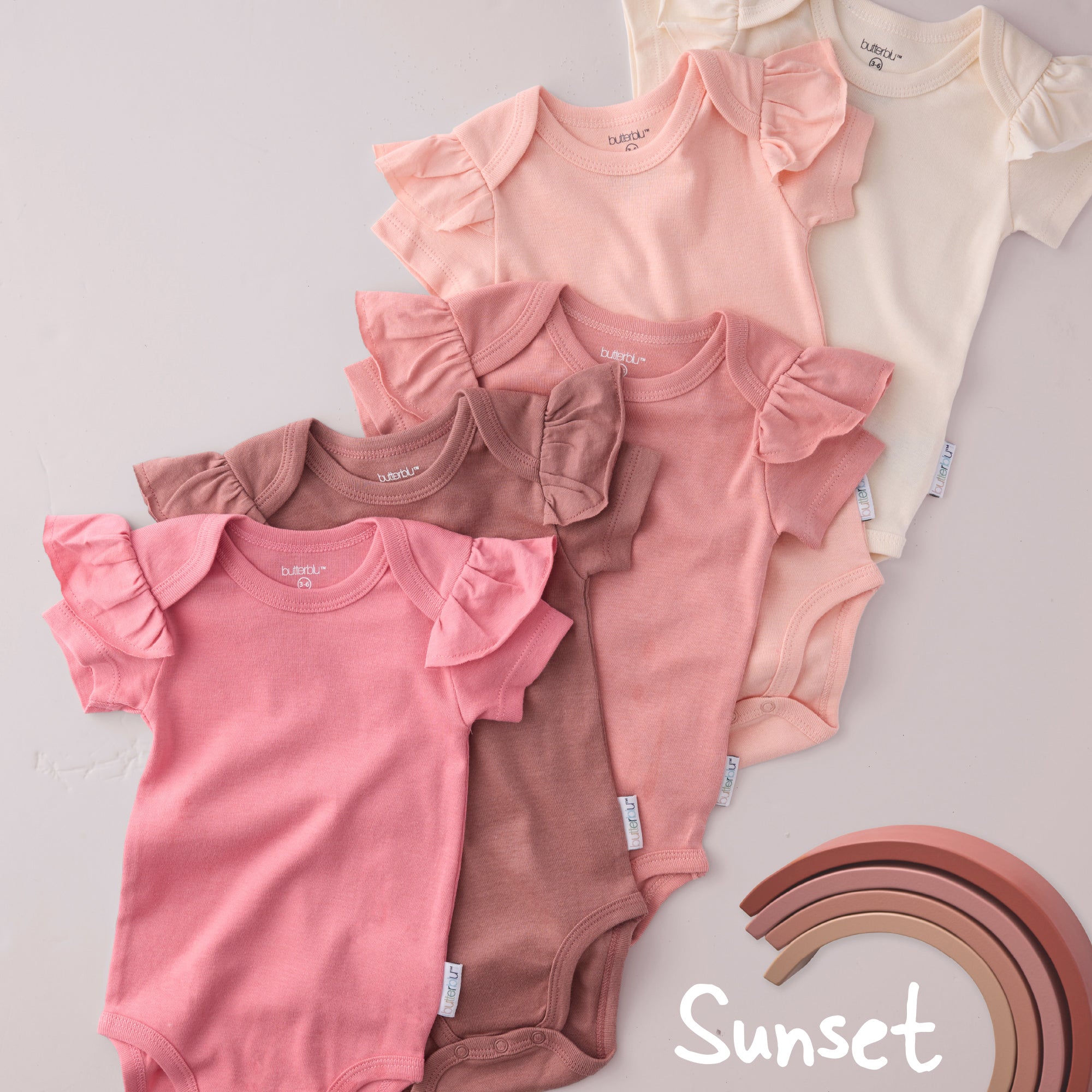 Collection of baby bodysuits in pink and brown shades on a light gray background with 'Sunset' text.