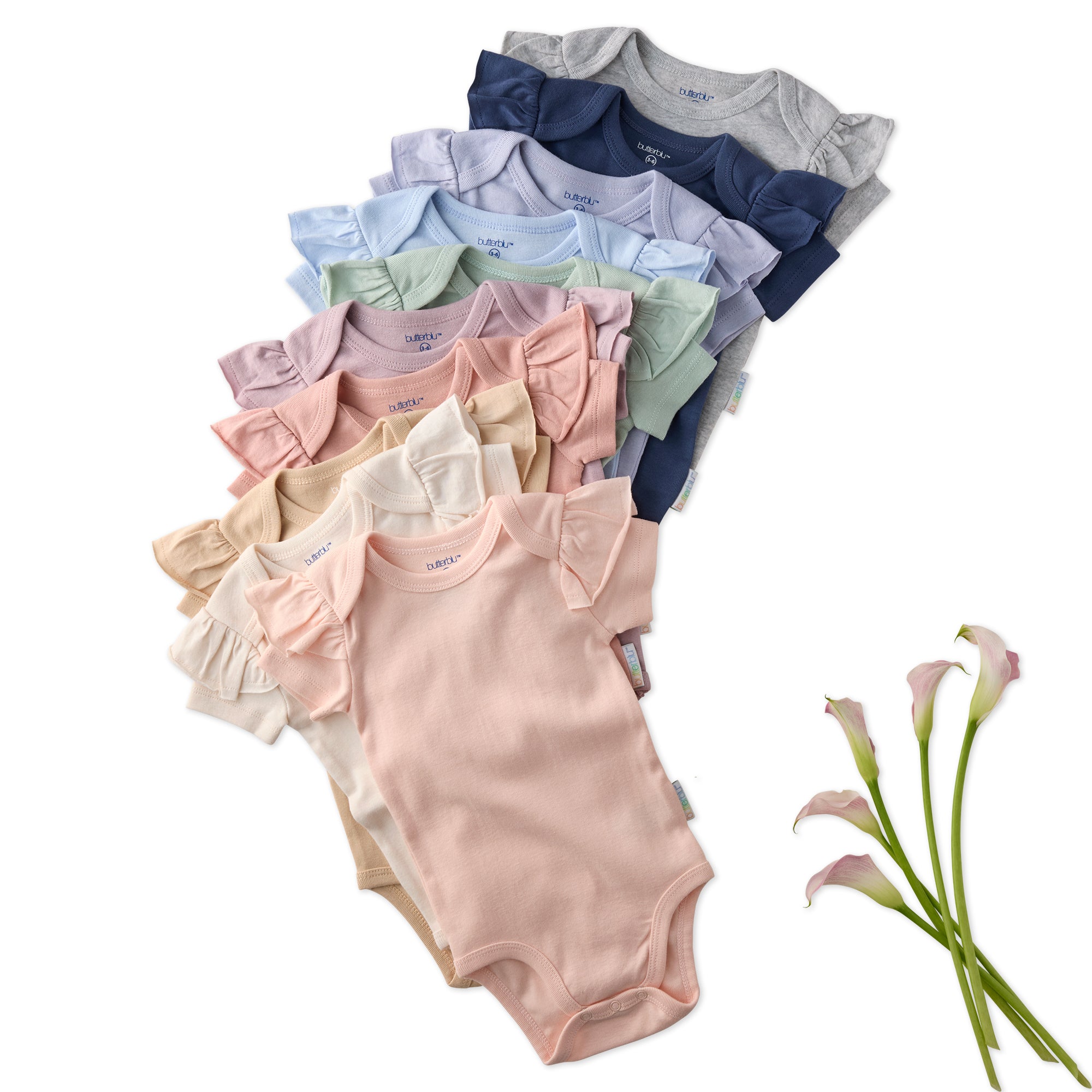 Stack of colorful baby bodysuits with a white background and calla lilies.