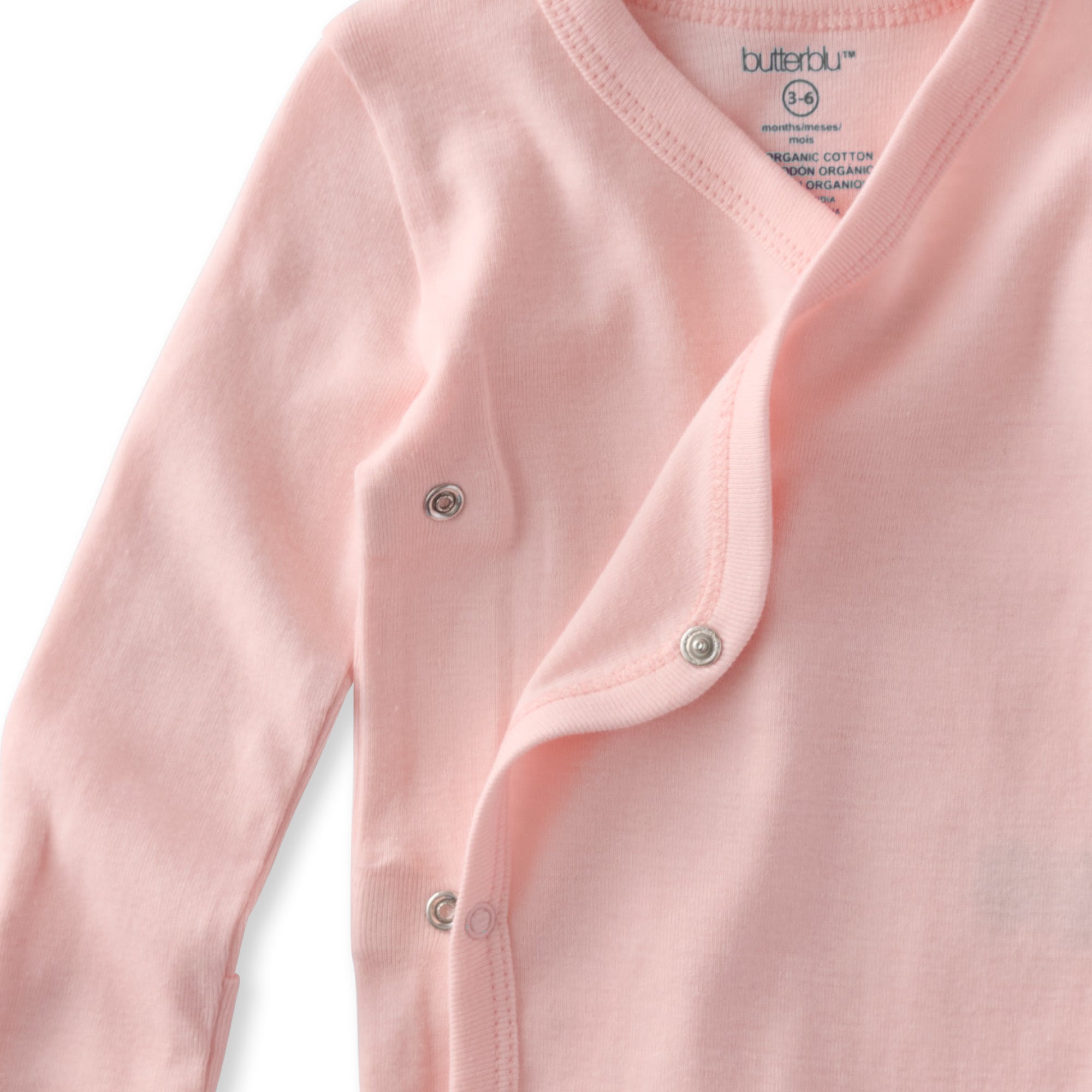 Close-up of a pink baby cardigan with buttons, featuring the brand 'butterfly'.