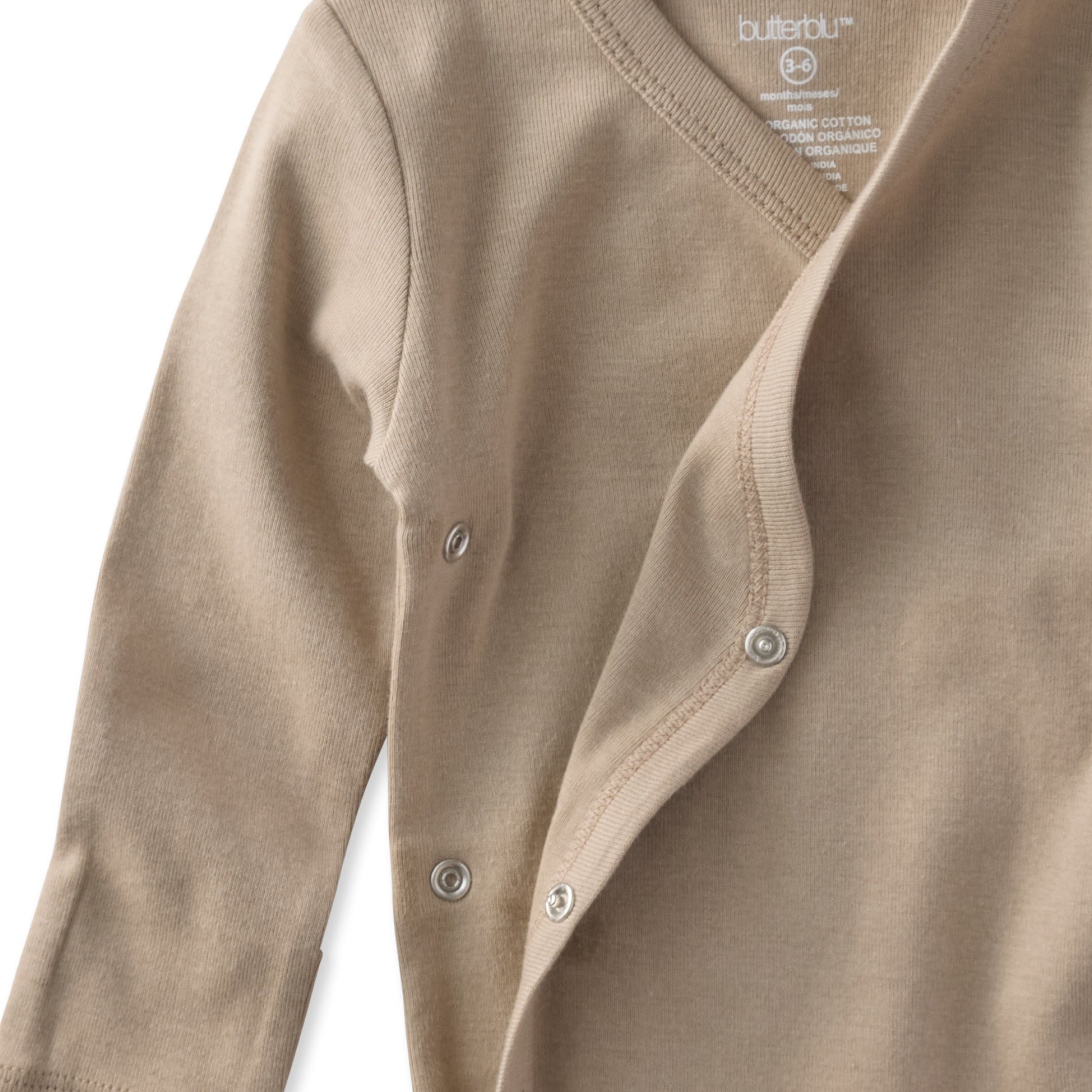 Close-up of a brown baby cardigan with buttons on a white background