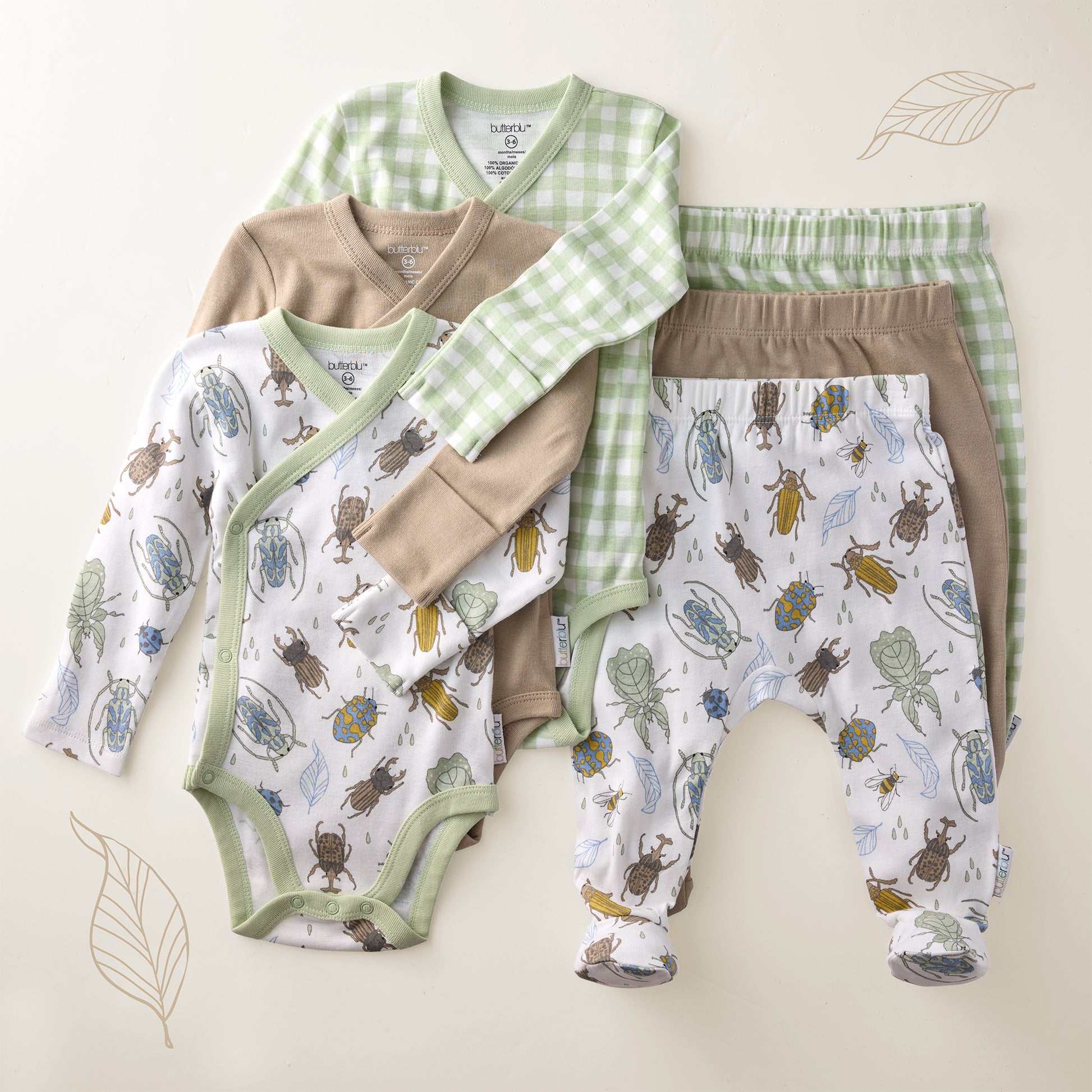 Baby clothing set with bodysuit, pants, and cardigan on a beige background