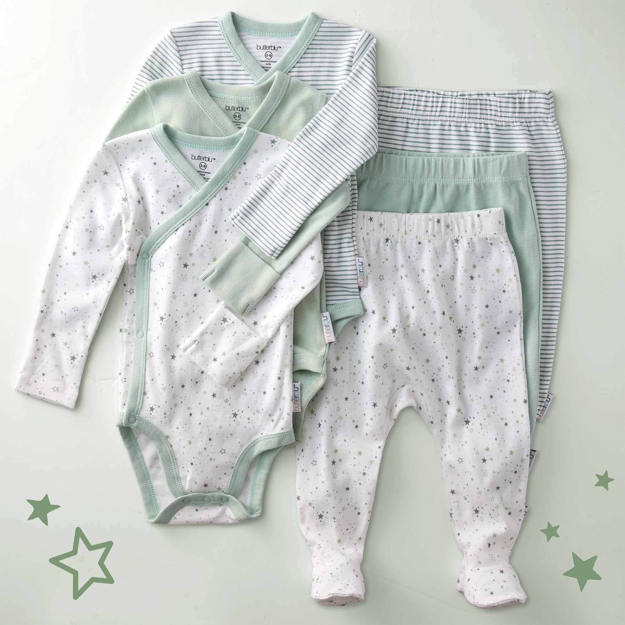 Baby clothing set with onesie and pants on a light green background