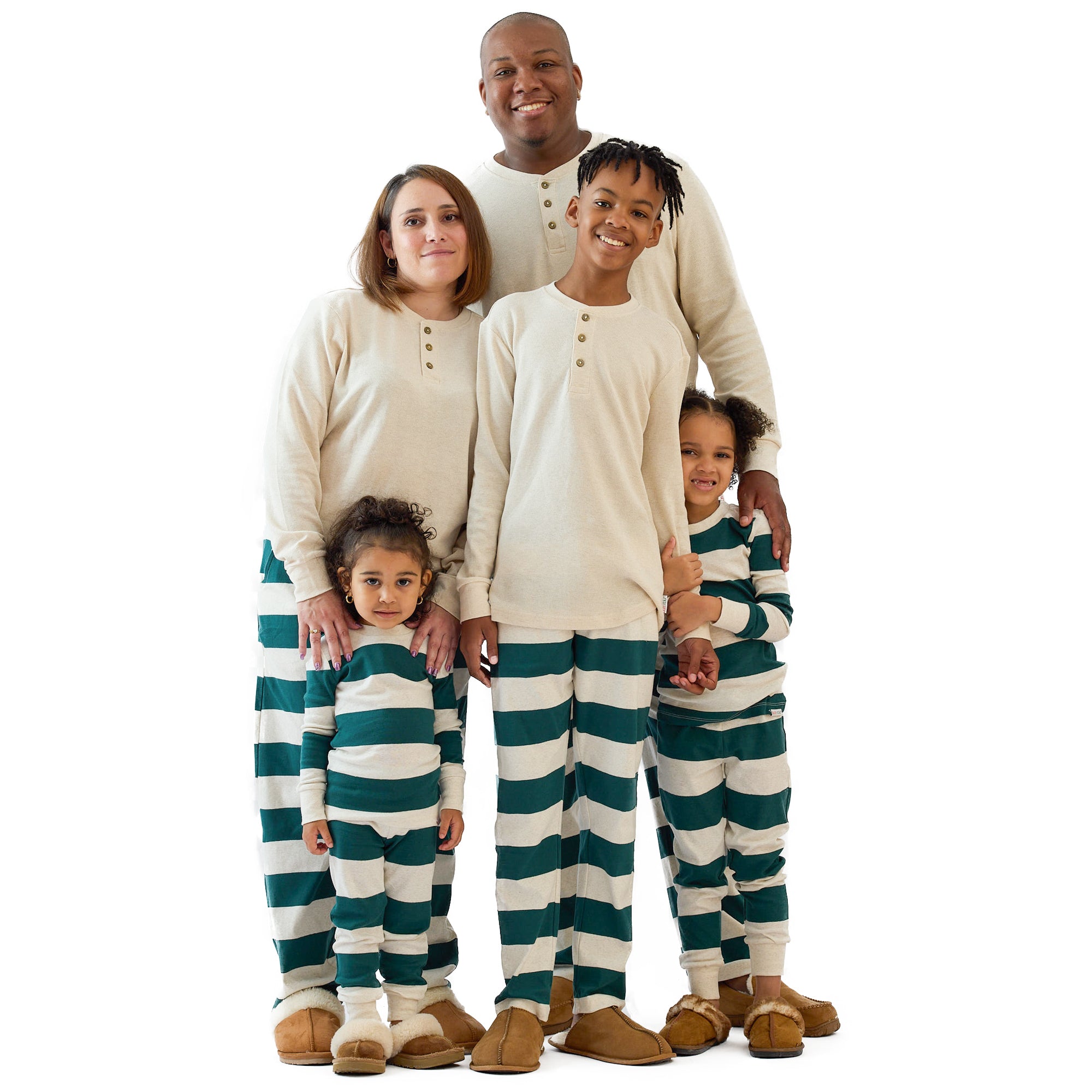 Family of five wearing matching green and white striped pajamas on a white background