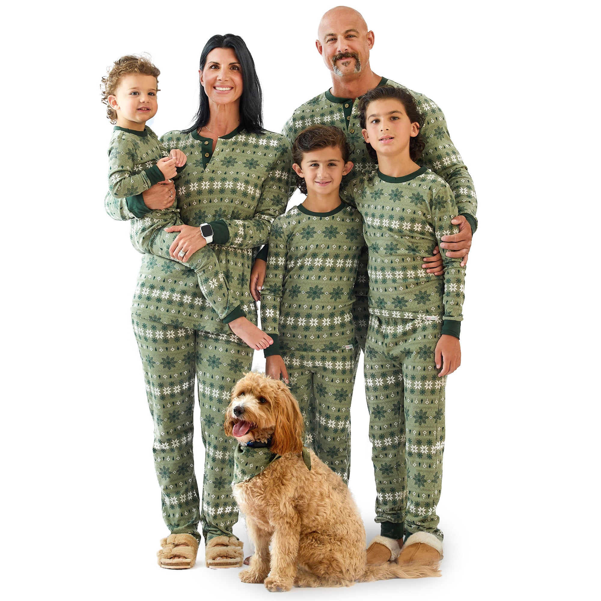 Family of five wearing matching green plaid pajamas with a dog on a white background
