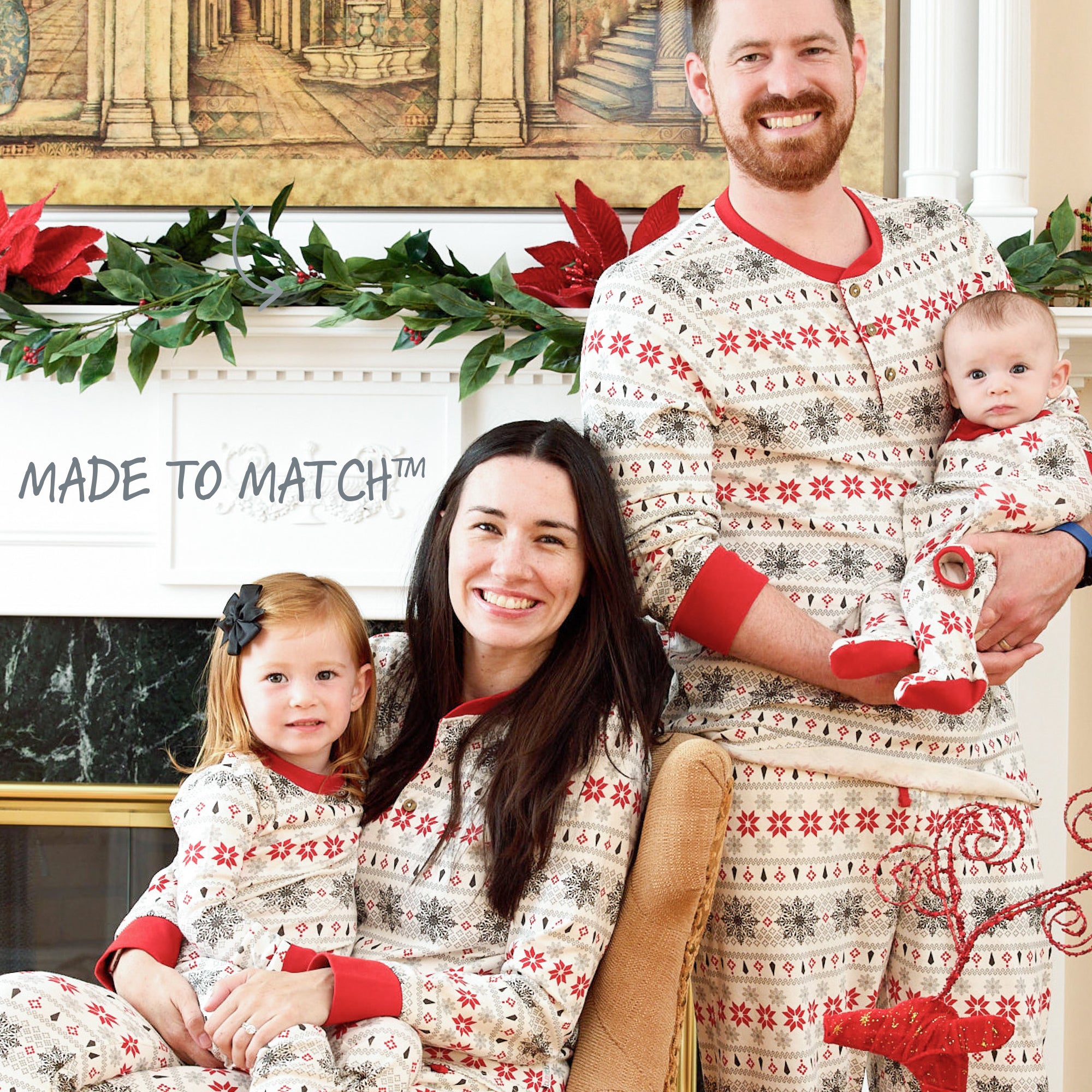 Family of four wearing matching holiday pajamas in a festive living room.