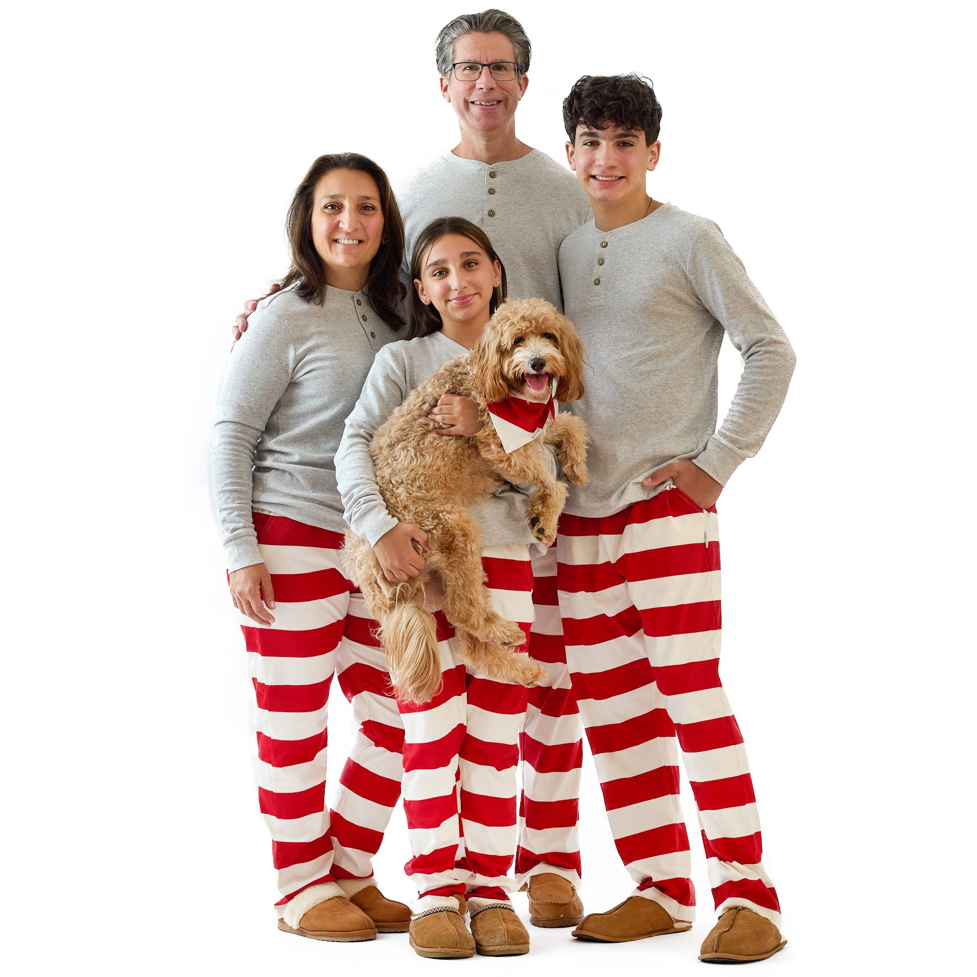 Family of four wearing red and white striped pajama pants with a dog on a white background