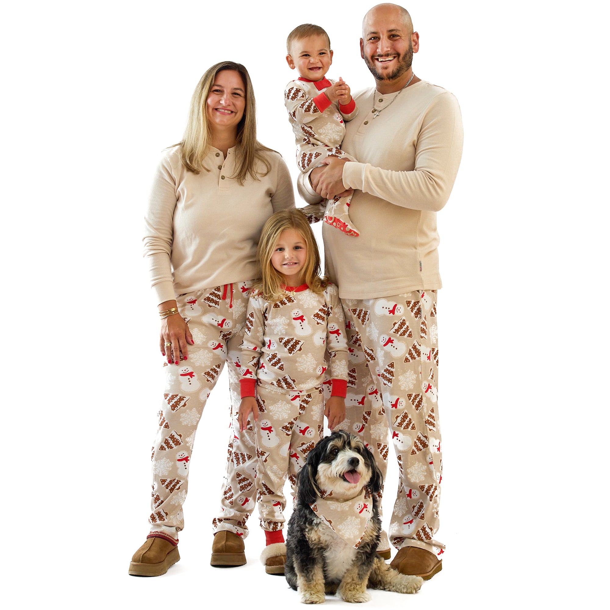 Family of four wearing matching pajamas with a dog on a white background