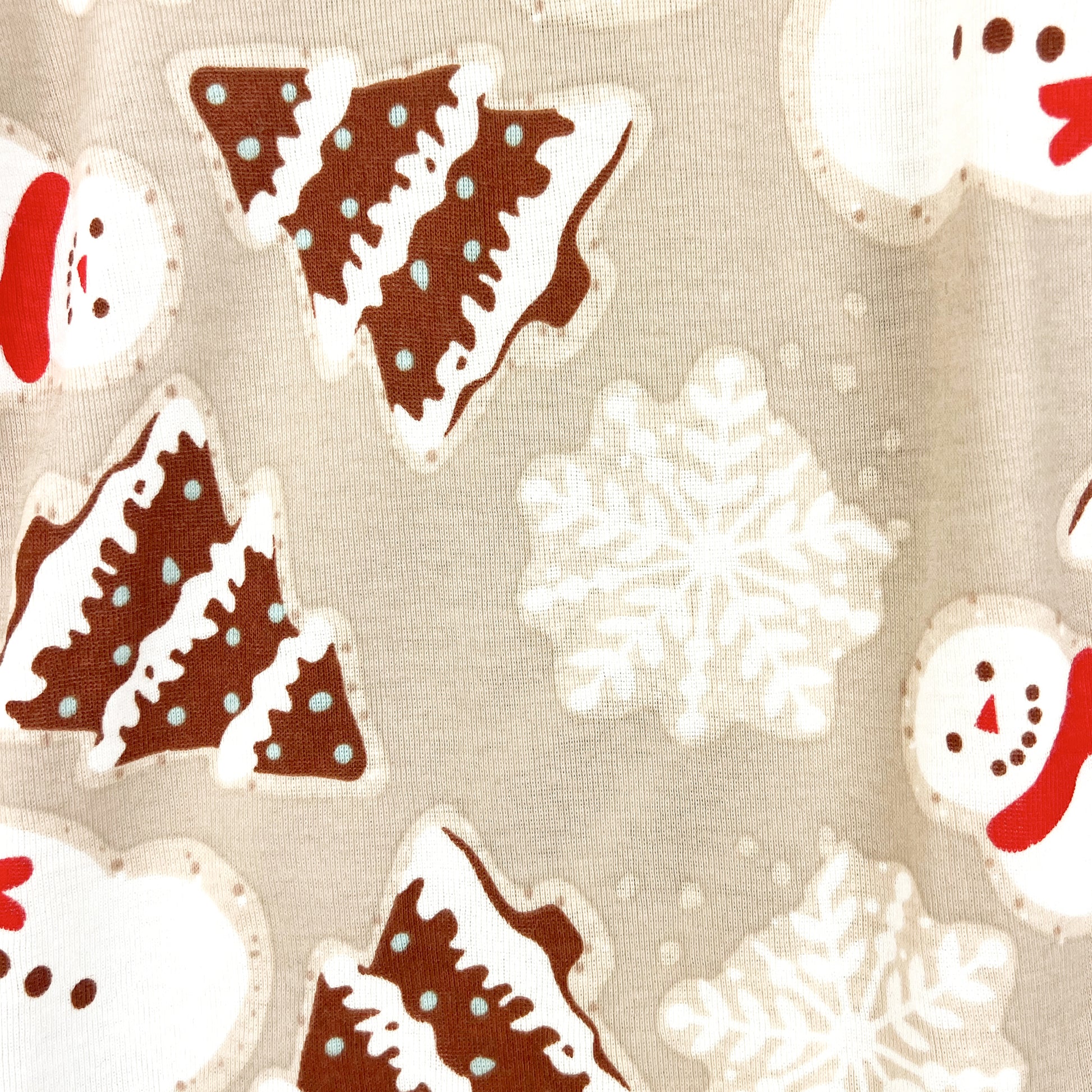 Pattern of gingerbread men, snowflakes, and Christmas trees on a beige background