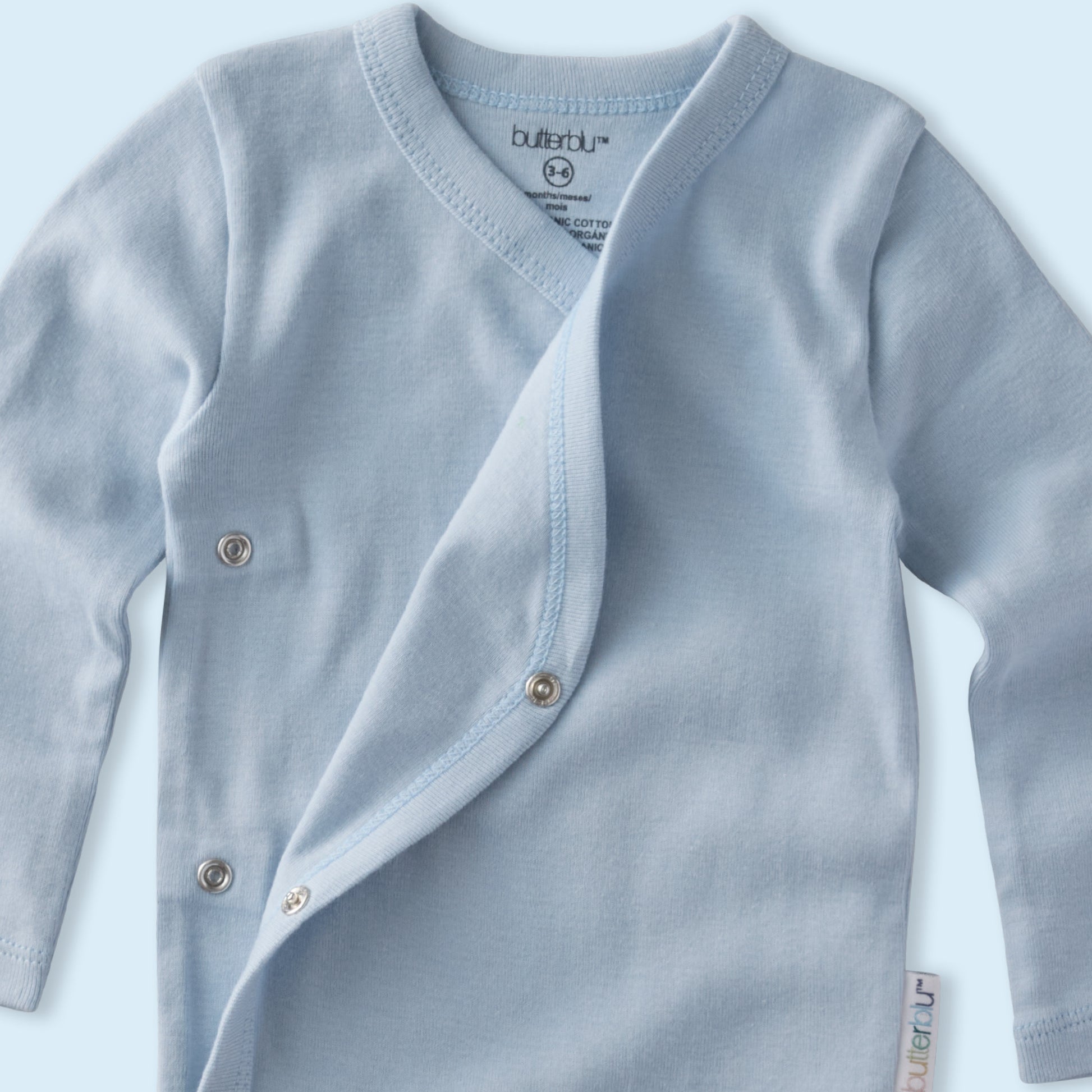 Light blue baby cardigan with buttons on a light blue background