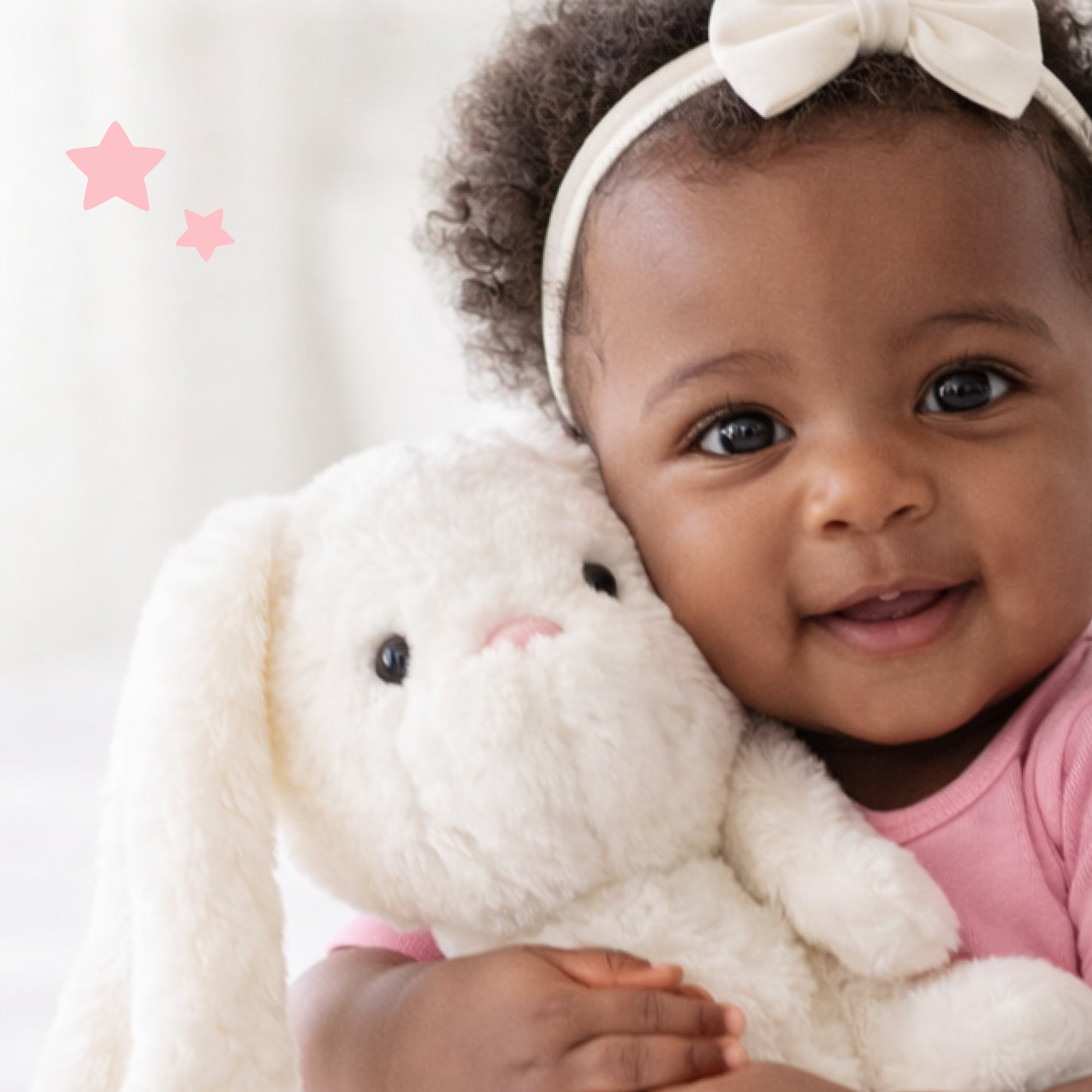Baby holding a plush toy with a white background