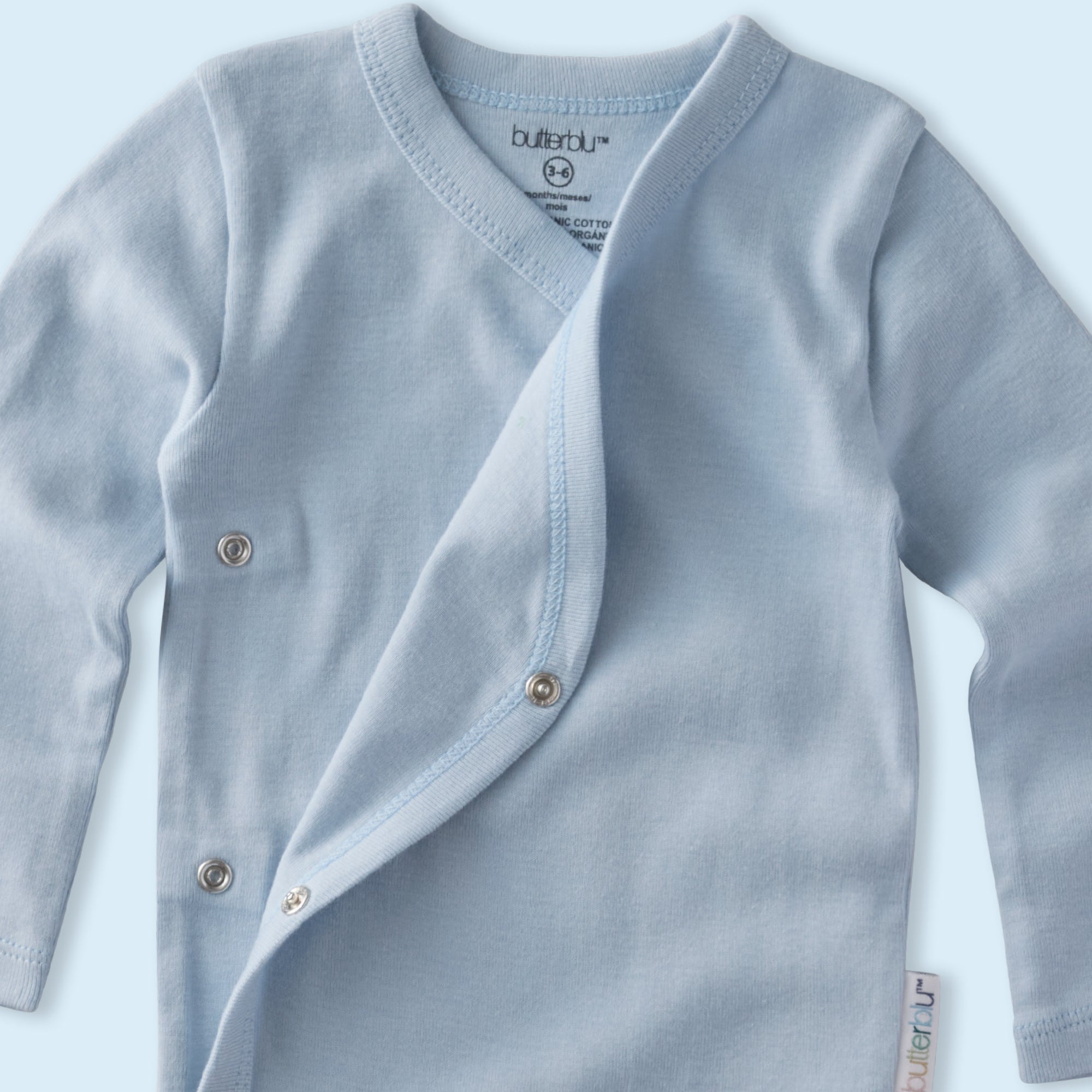 Light blue baby cardigan with buttons on a light blue background