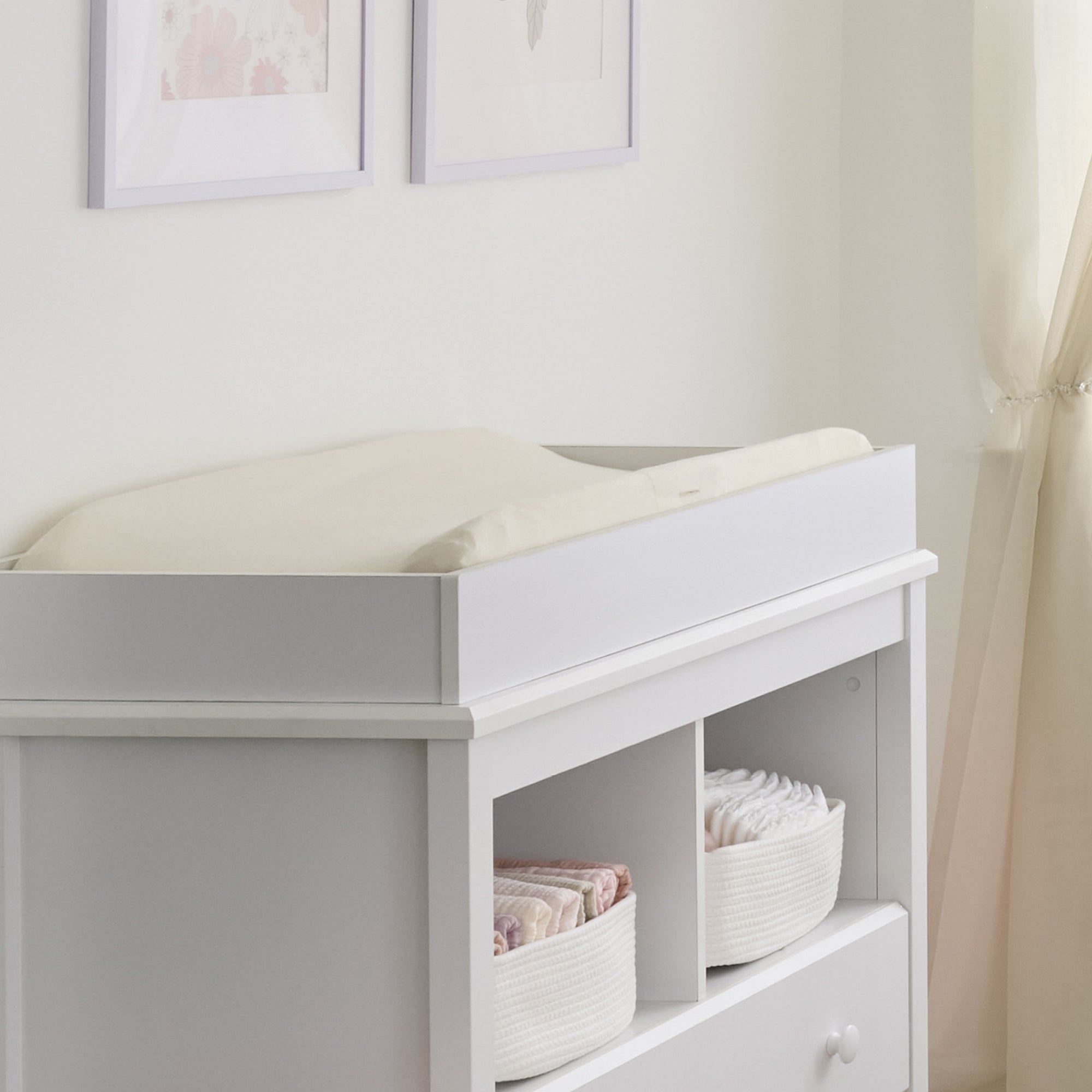 White changing table with shelves in a nursery setting