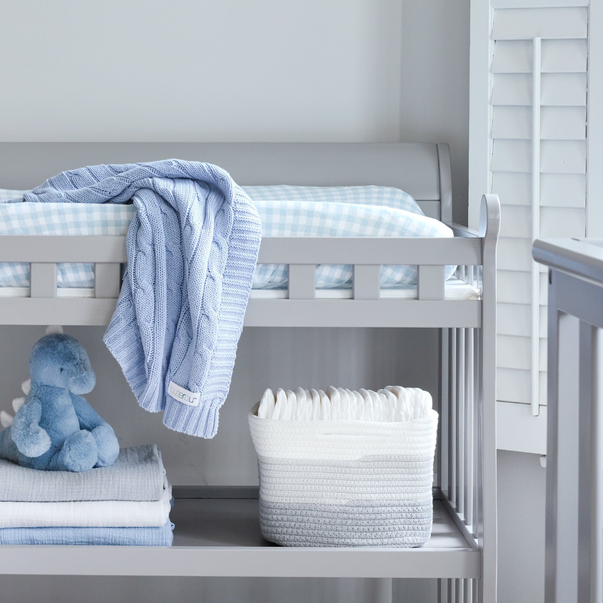 Nursery with a crib, baby blanket, toy, and basket.