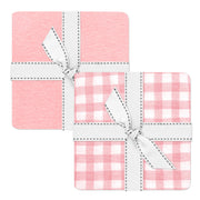 Set of three pink and white checkered coasters with white bows on a white background