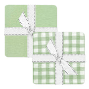 Two green checkered coasters with white ribbons on a white background