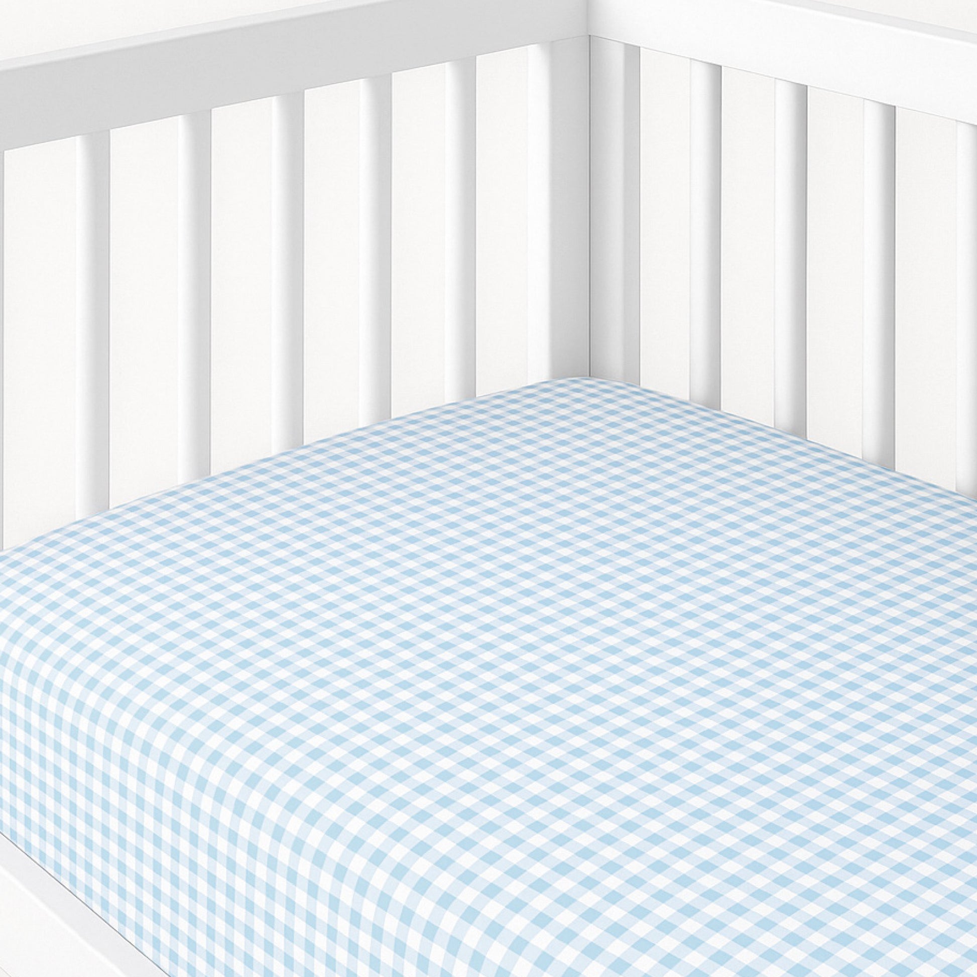 Crib with blue and white checkered fitted sheet on a white background