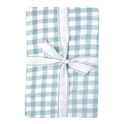 Blue and white checkered baby crib sheet with a white bow on a white background