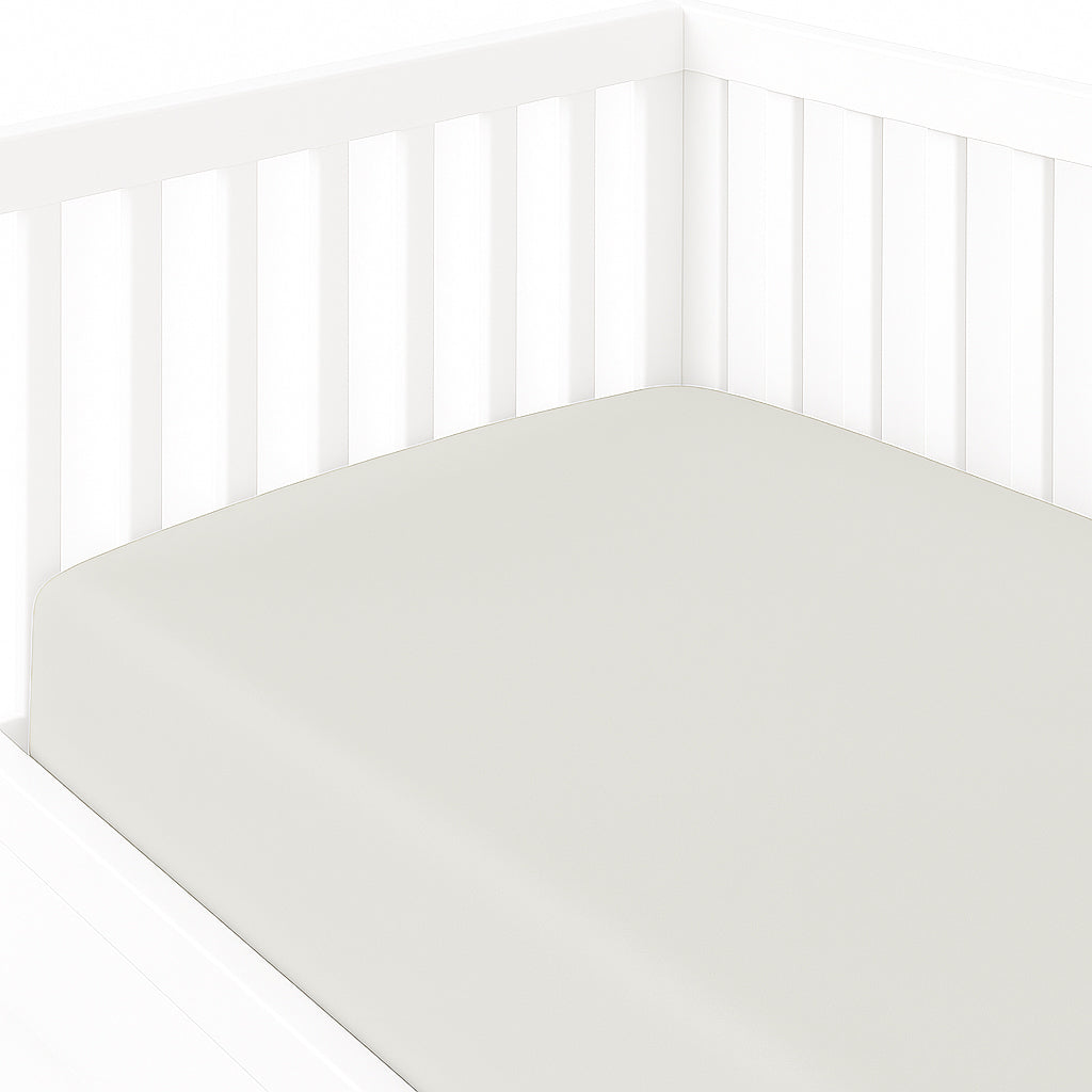 White crib with a white mattress on a white background