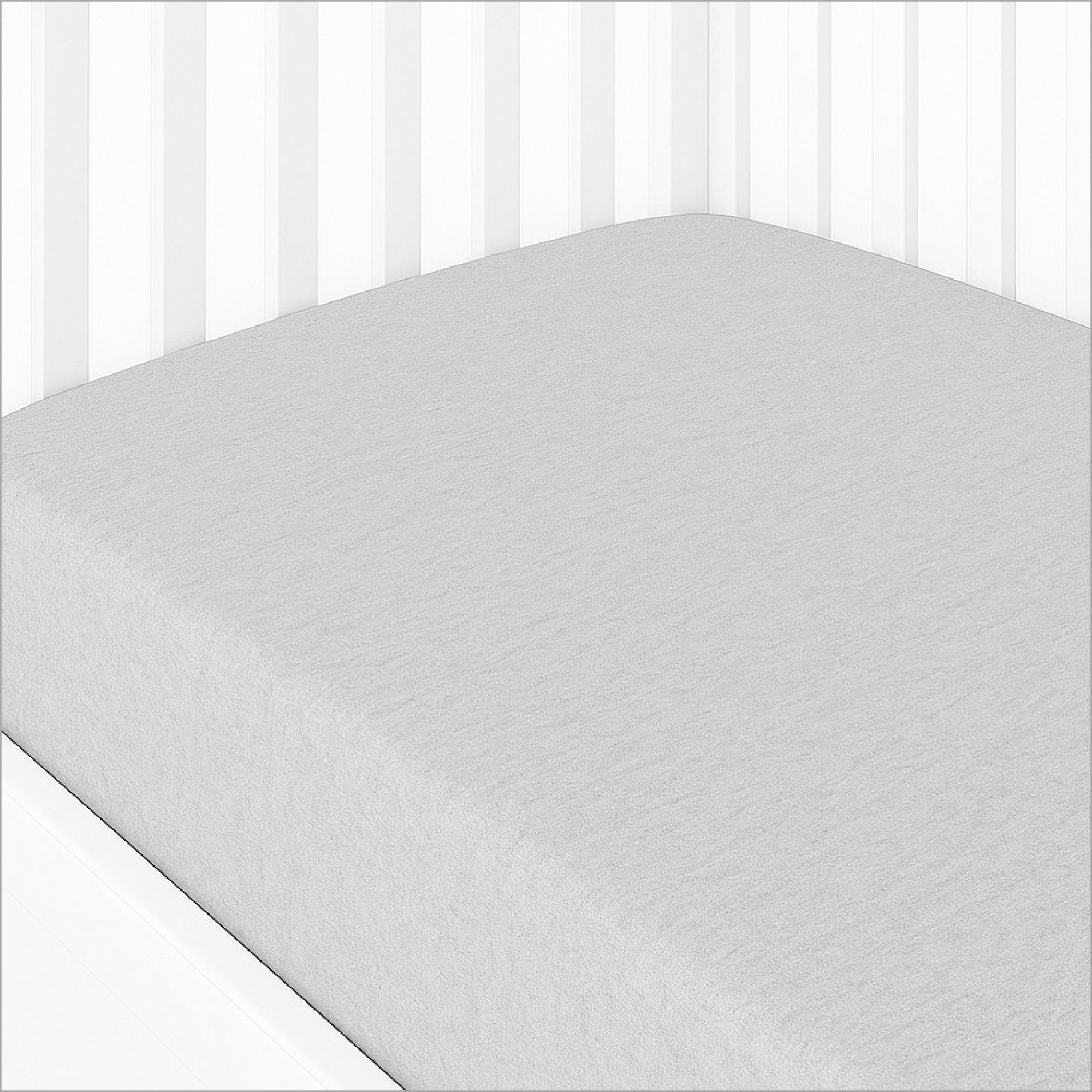 Gray crib sheet on a crib with white bedding in the background