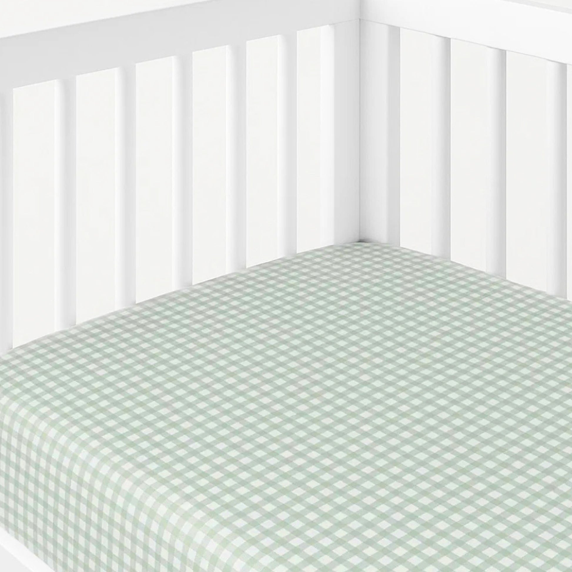 Crib with a green and white checkered fitted sheet on a white background