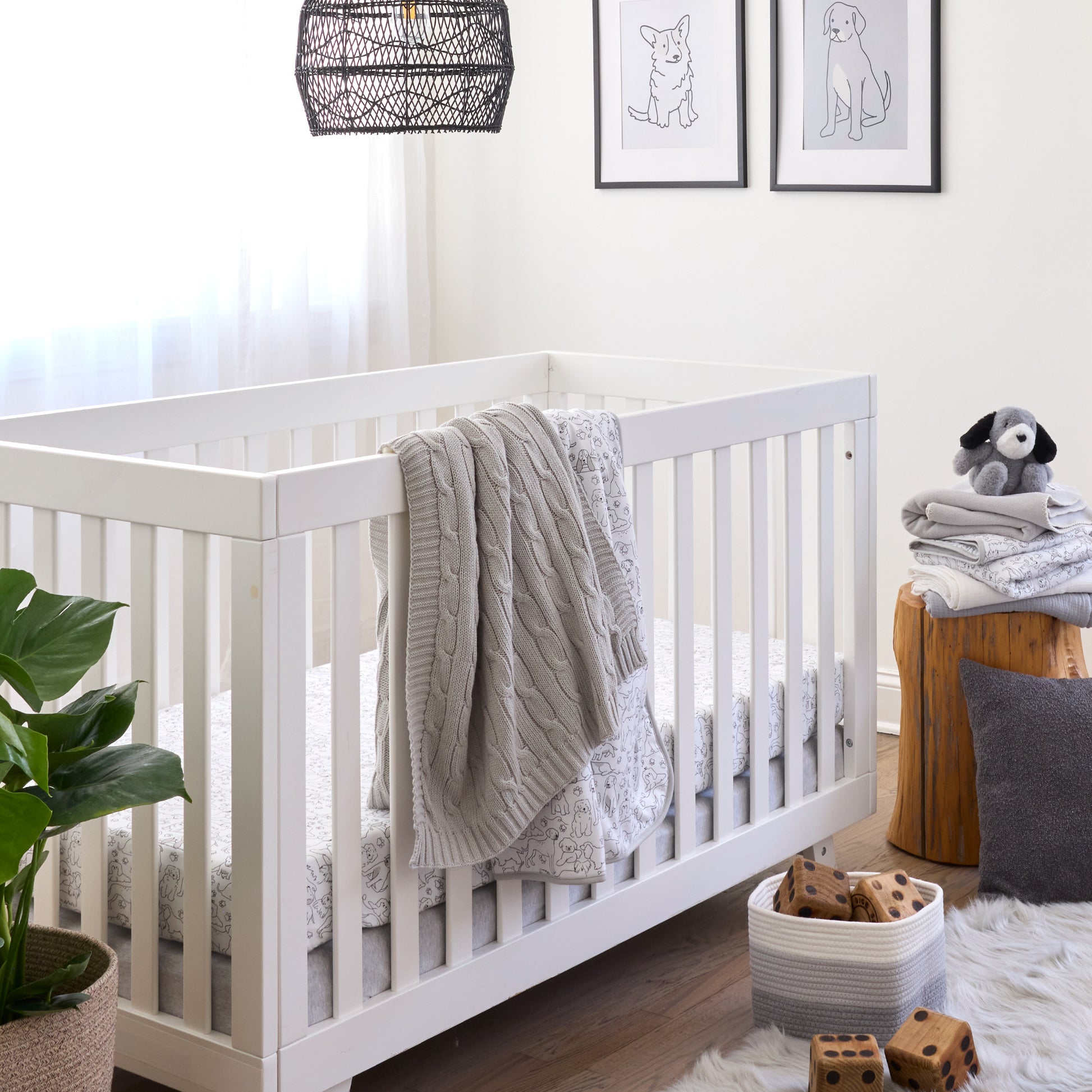 Nursery room with a white crib, gray blanket, and wooden stool with toys.