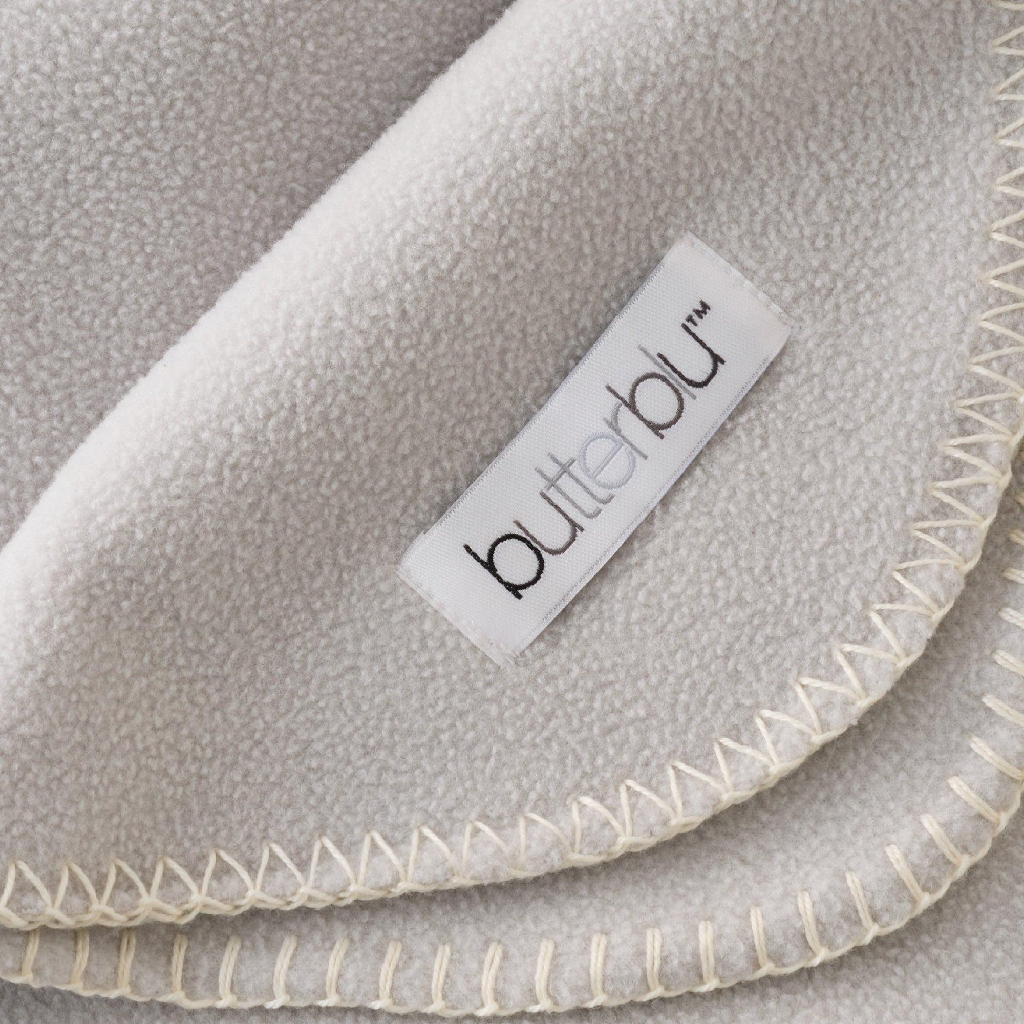 Gray fleece blanket with 'butterbu' label on a gray background