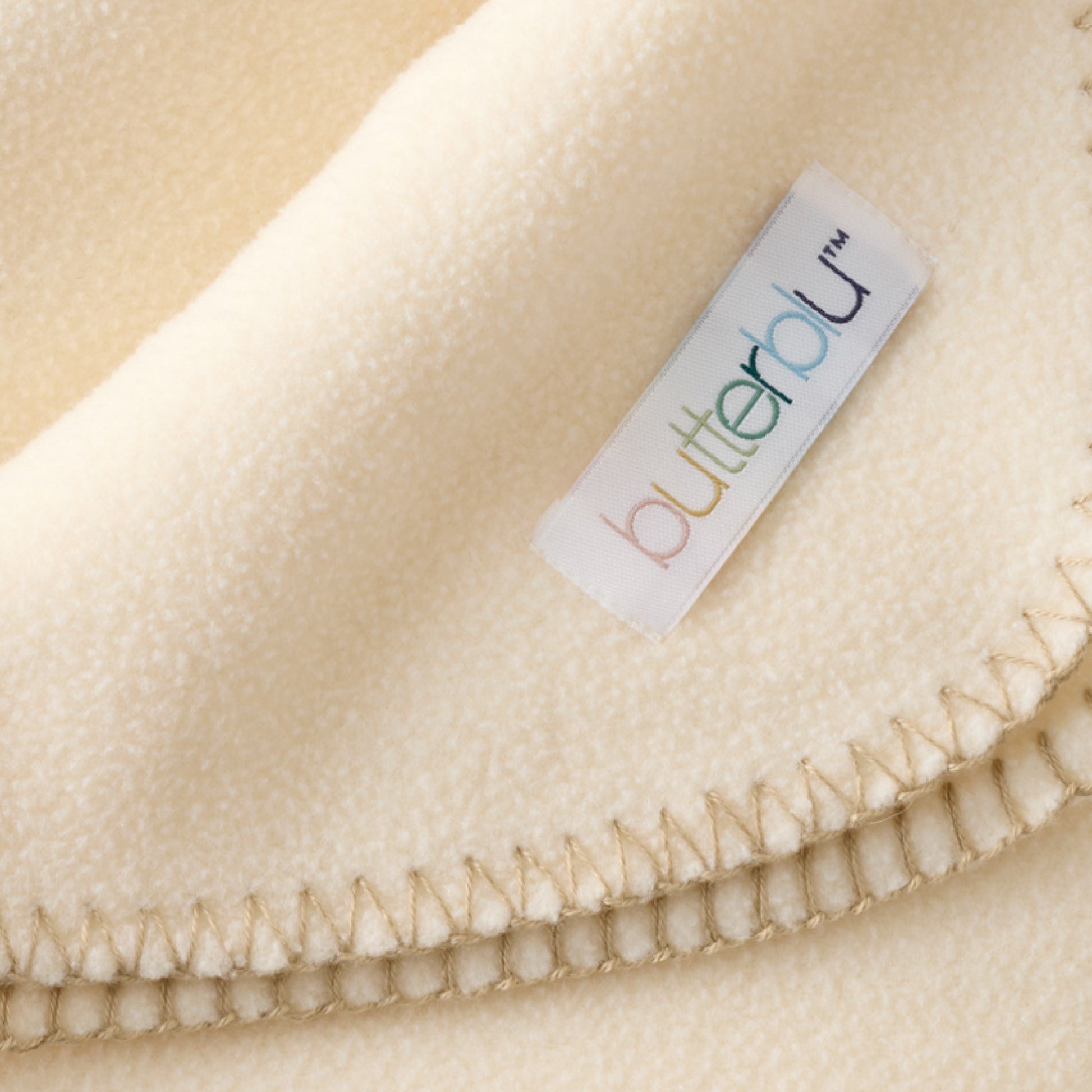 Close-up of a beige fabric with a 'butterblu' label.