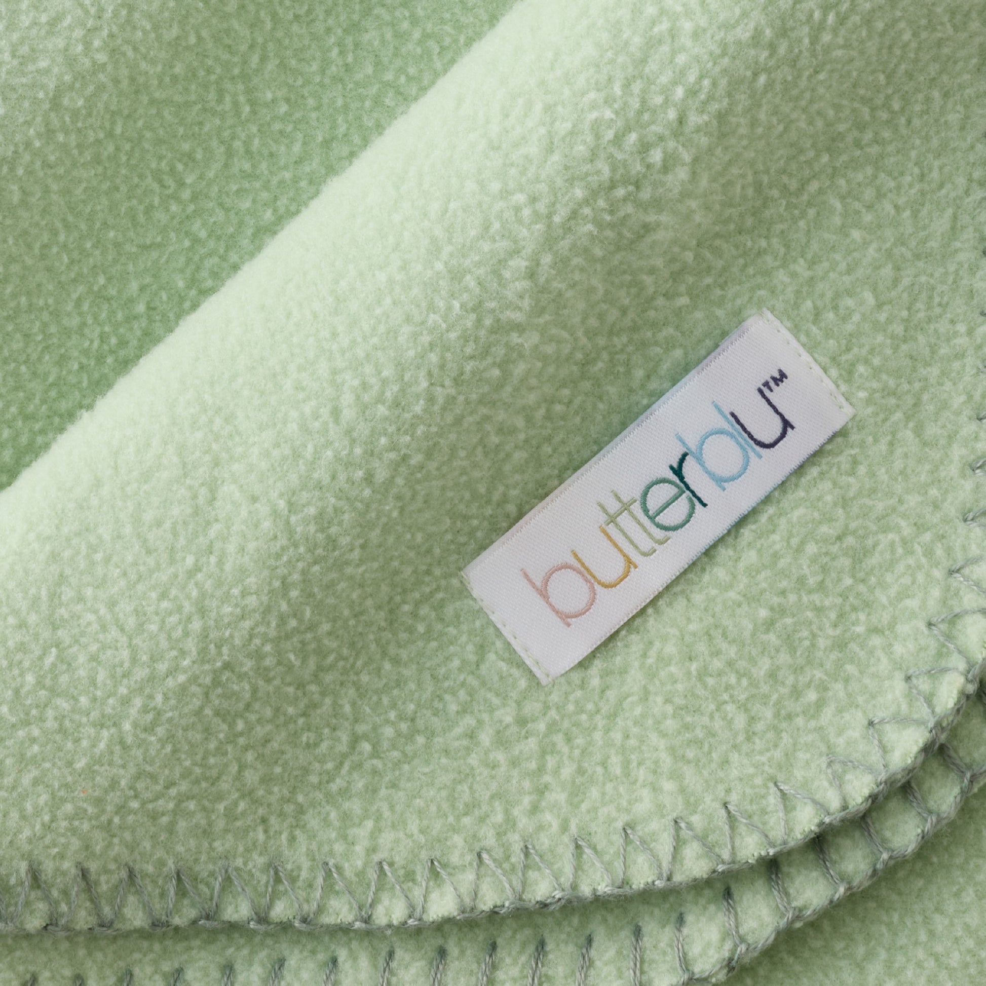 Close-up of a green fabric with a 'butterfly' brand label.