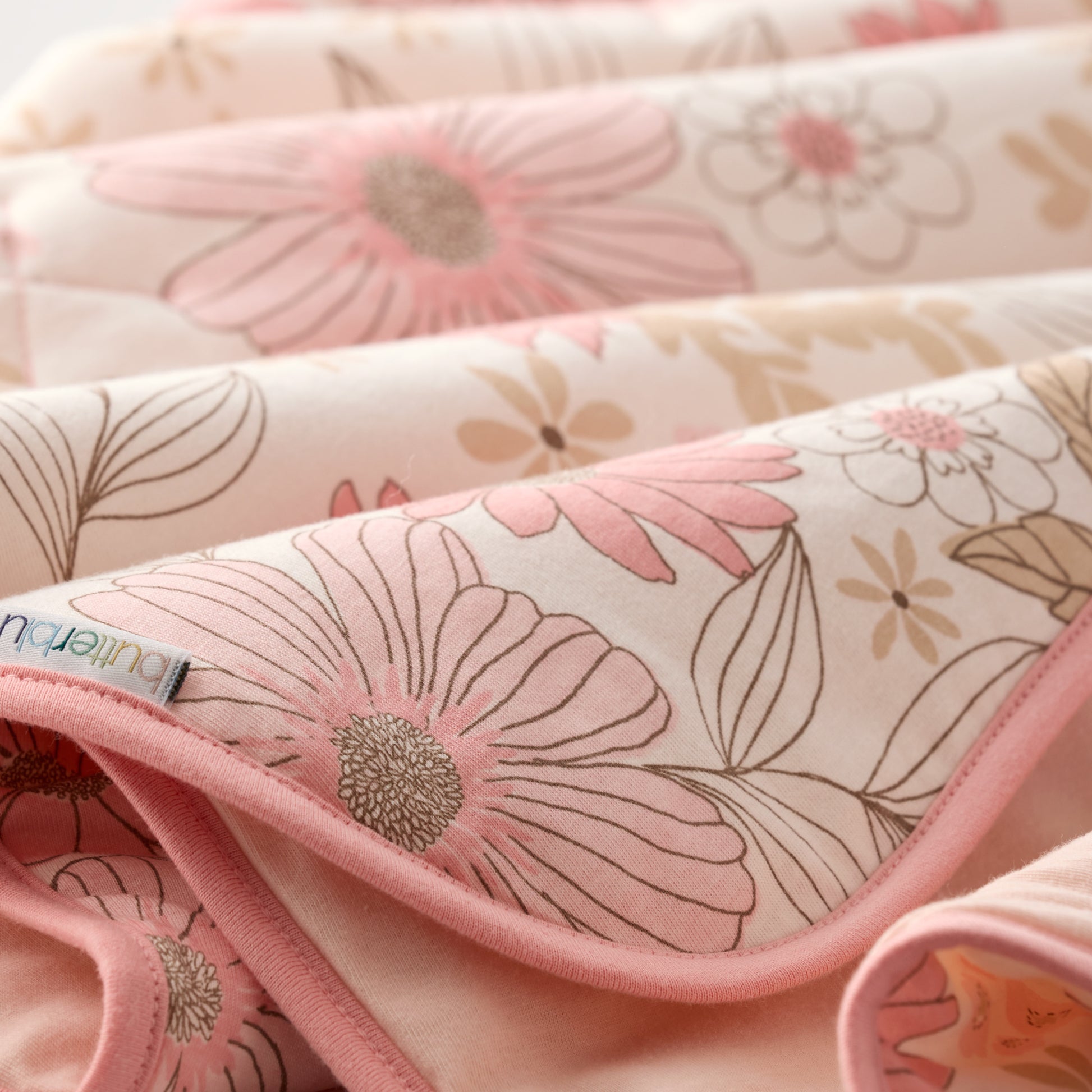 Floral-patterned fabric with a brand label on a pink background