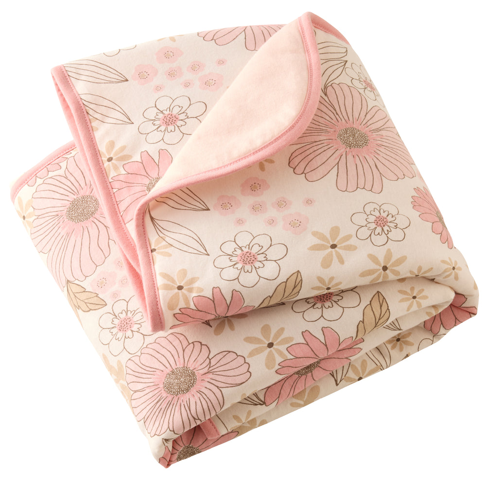 Floral-patterned blanket with pink border on a white background