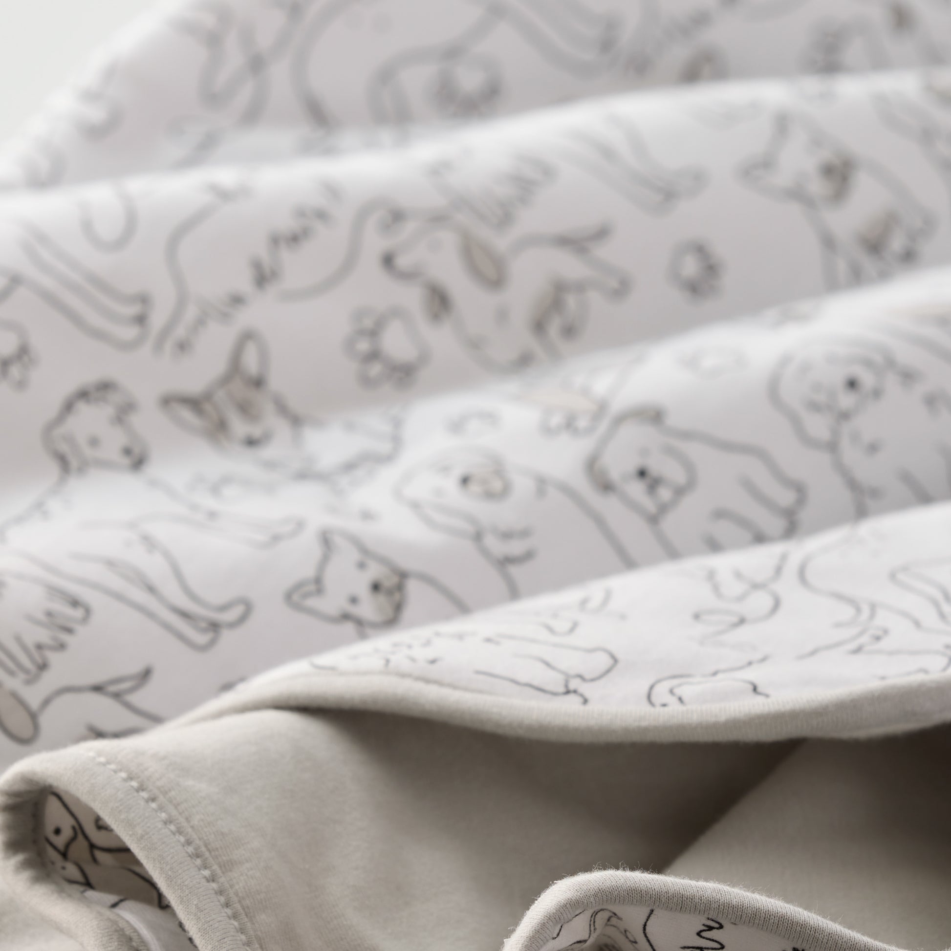 Folded fabric with cat pattern on a light gray background