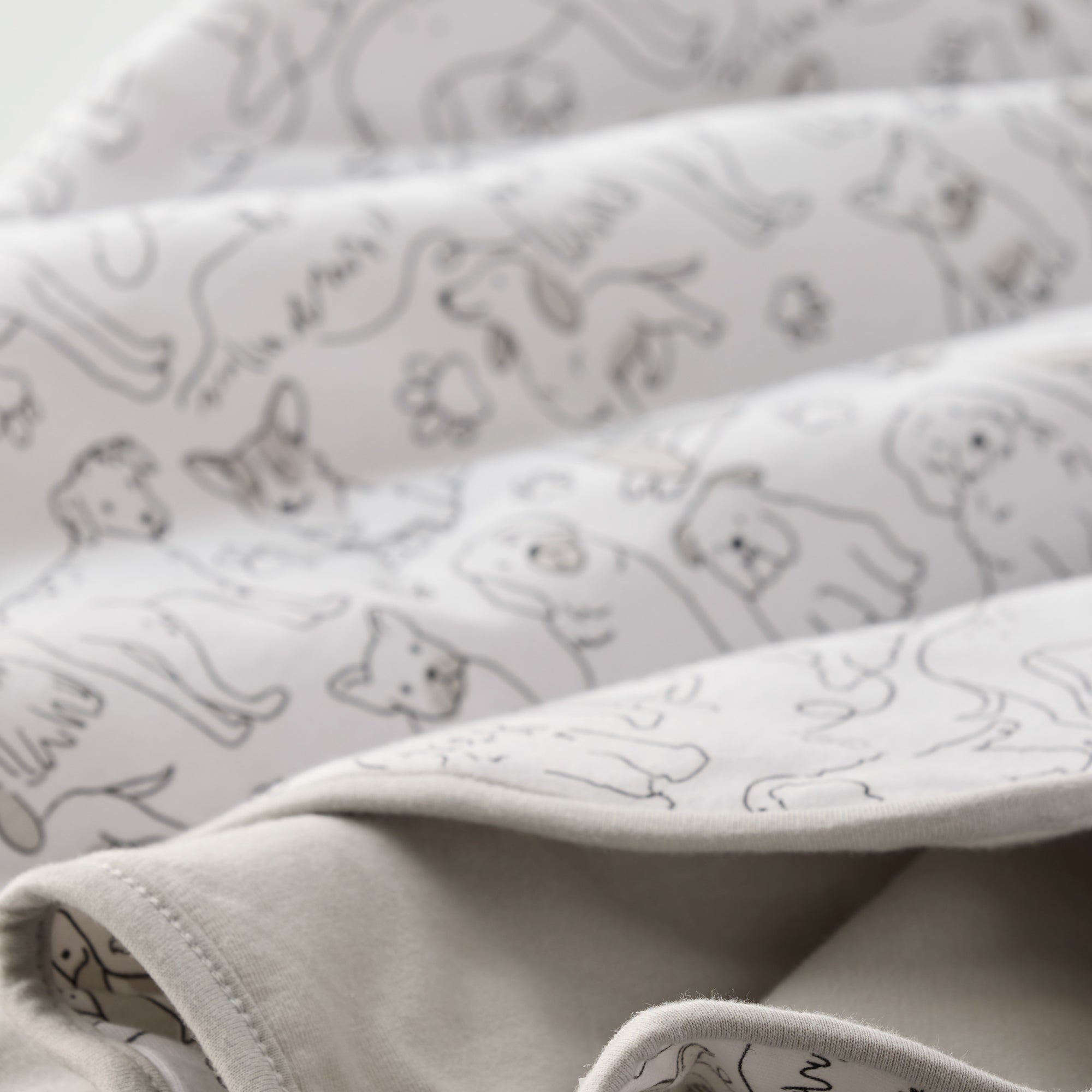 Folded fabric with cat pattern on a light gray background
