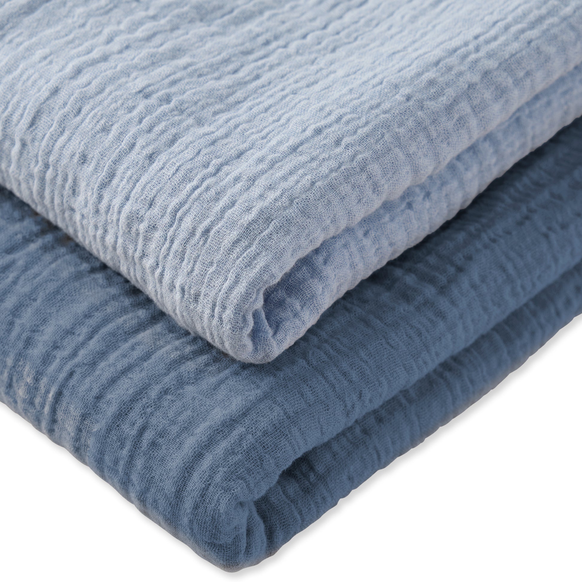 Stack of blue textured swaddle blankets on a white background