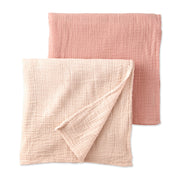 Two pink textured swaddling blankets on a white background