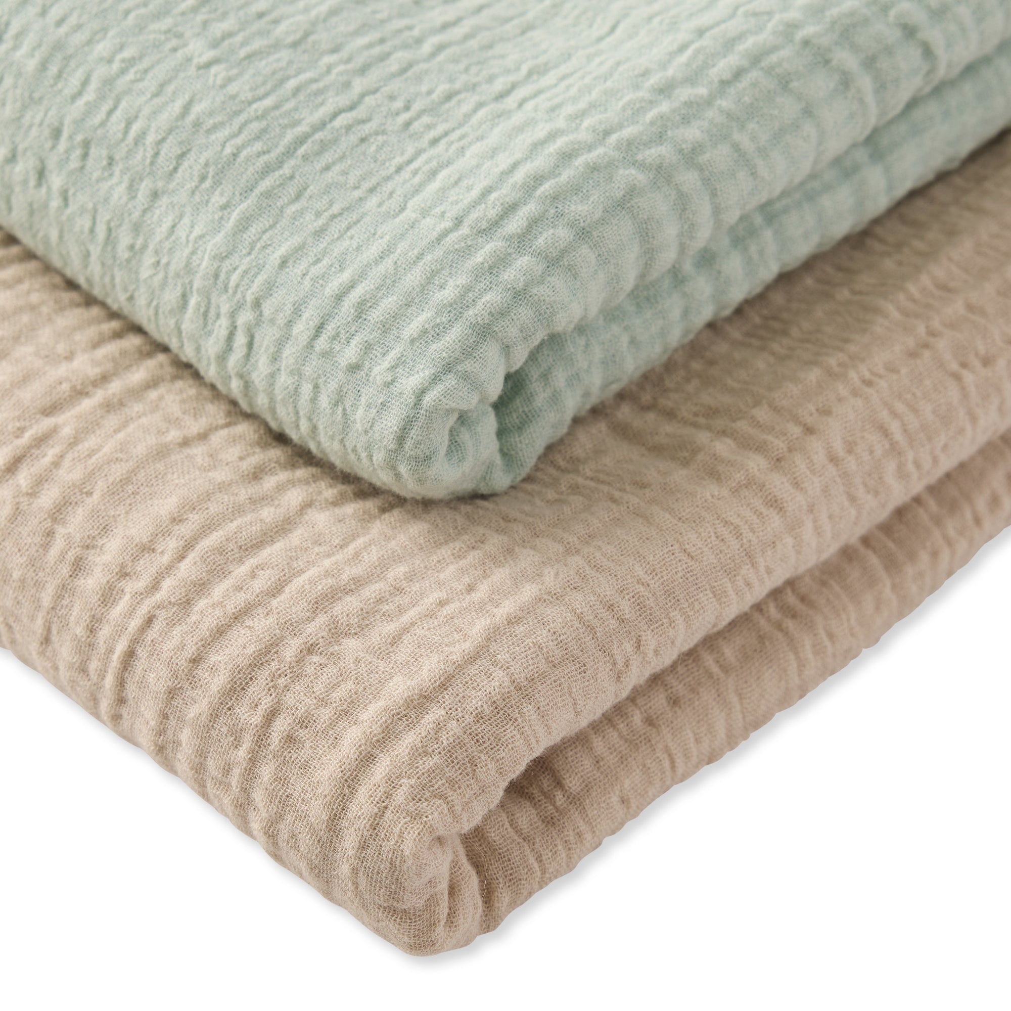 Two folded fabrics, one light green and one beige, on a white background