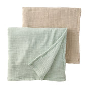 Two textured fabric swaddling blankets, one green and one beige, on a white background.