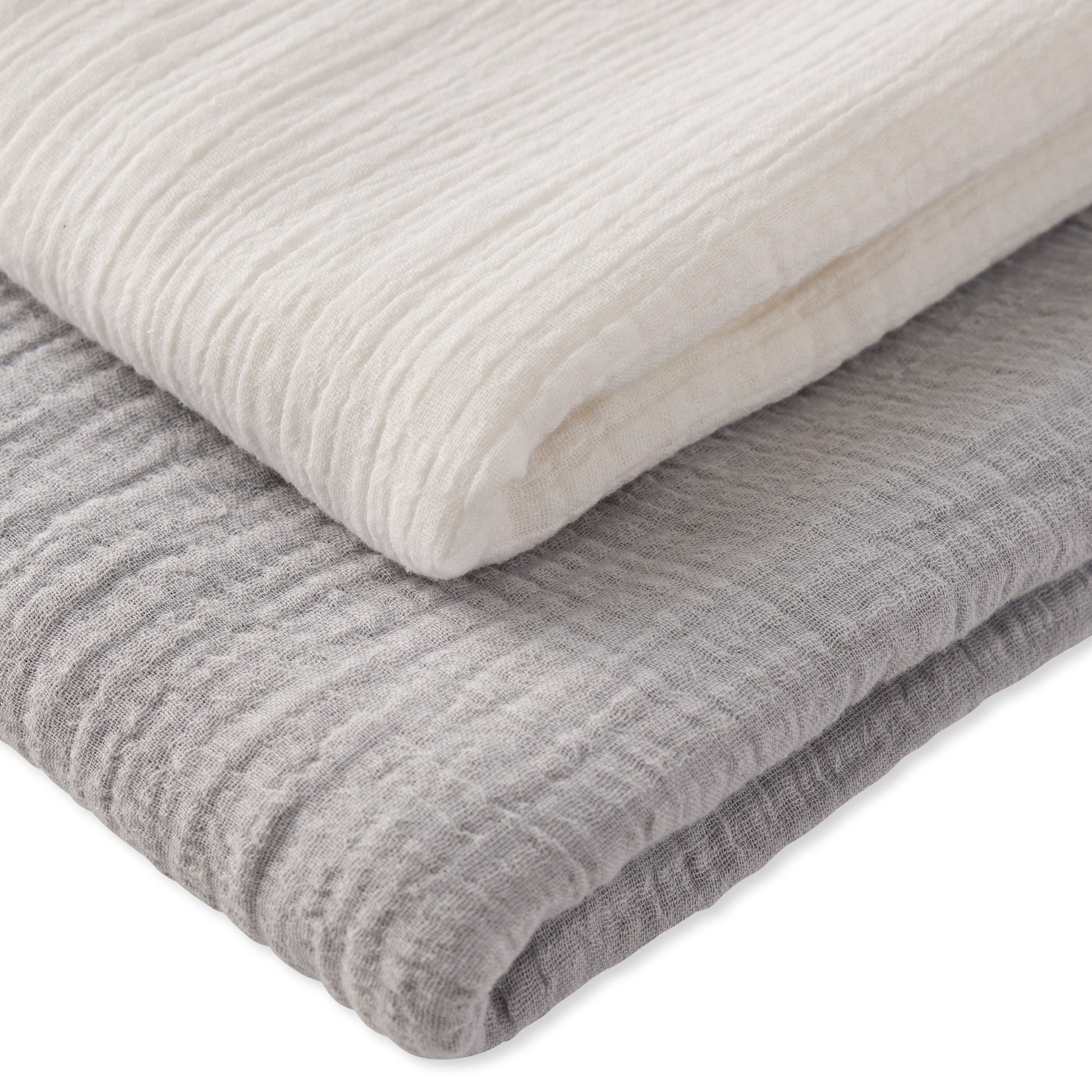 Two folded textured blankets, one white and one gray, on a white background.