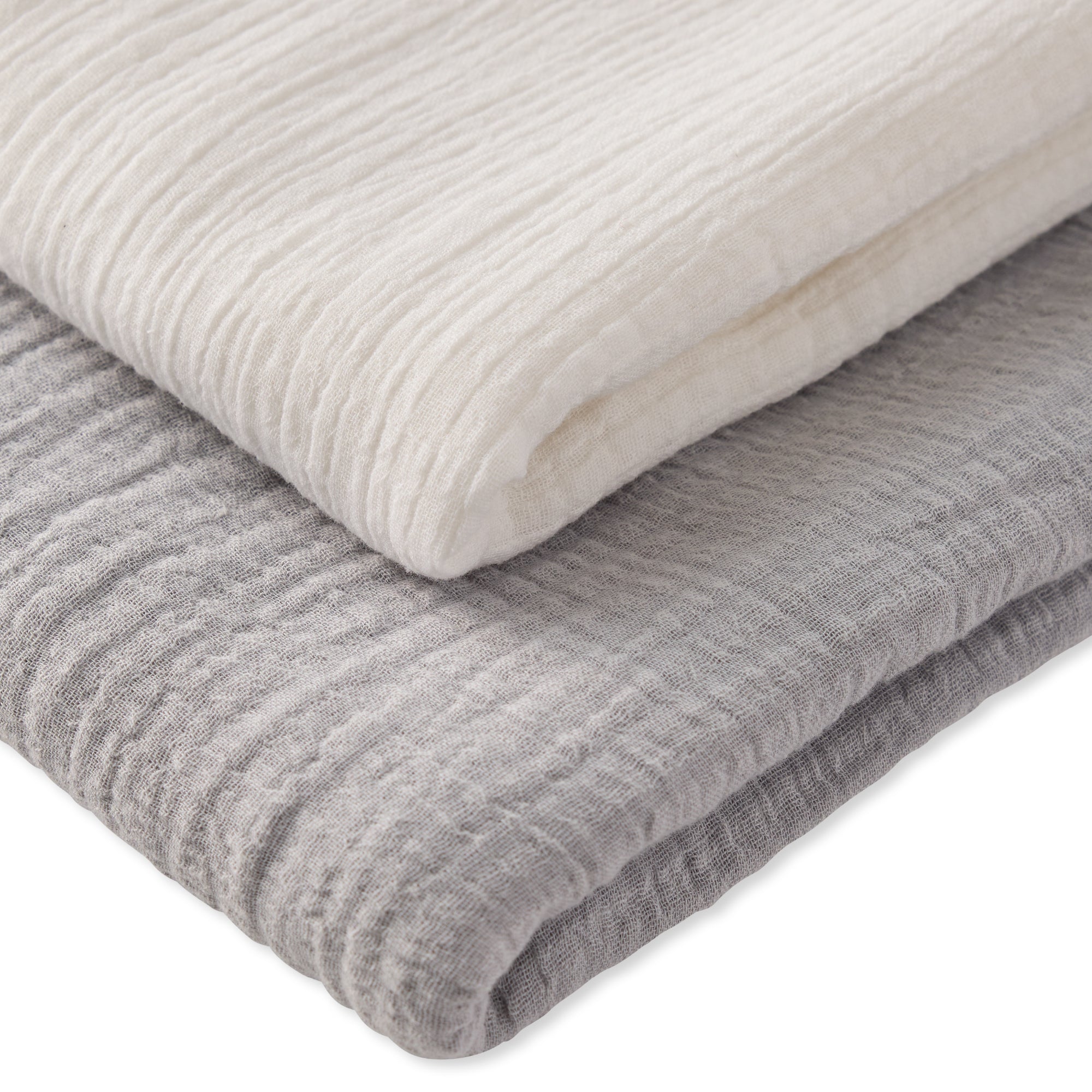 Two folded textured blankets, one white and one gray, on a white background.