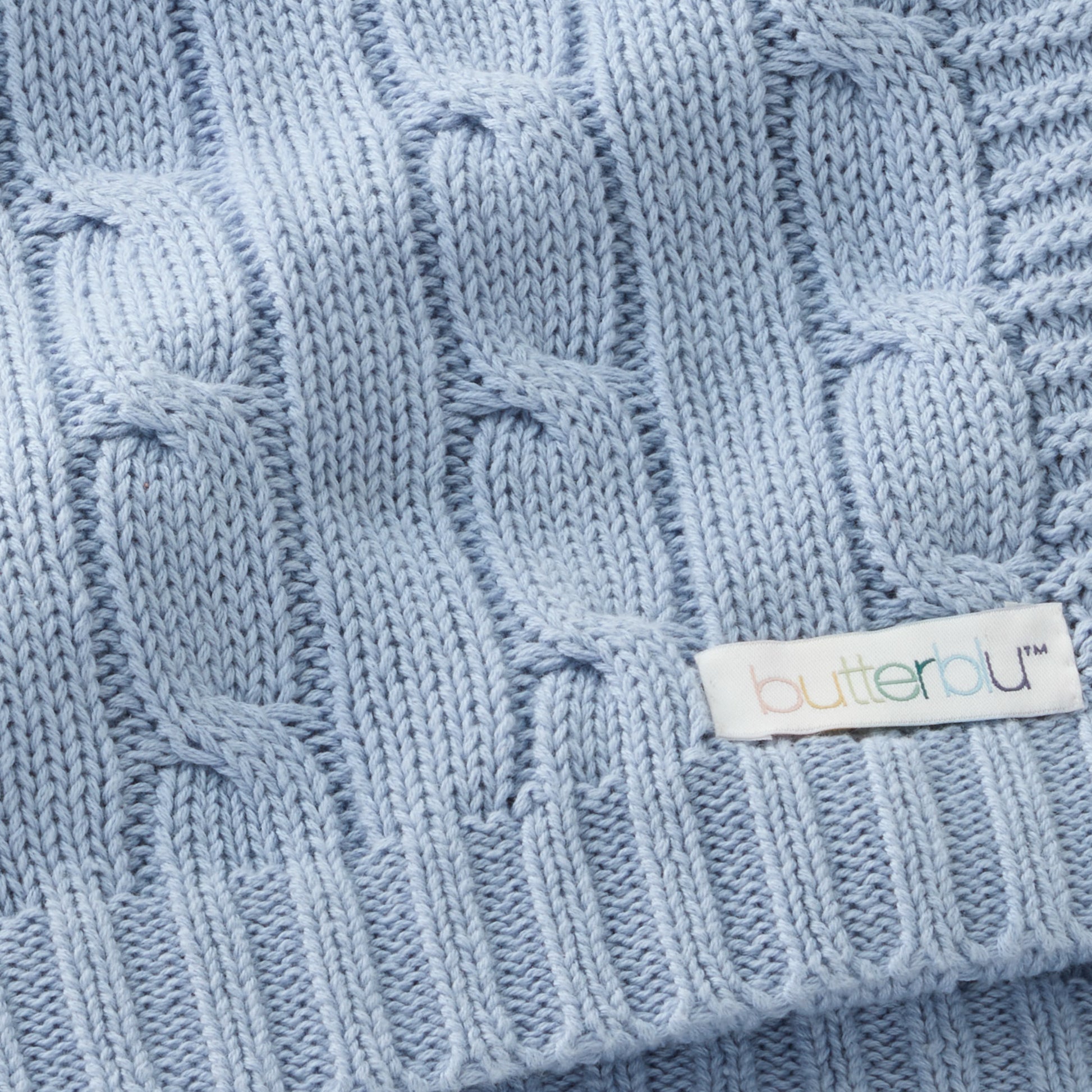 Close-up of a textured blue fabric with a 'butterblu' label.