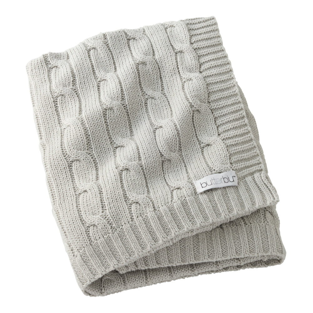 Folded gray knitted blanket with a brand label on a white background