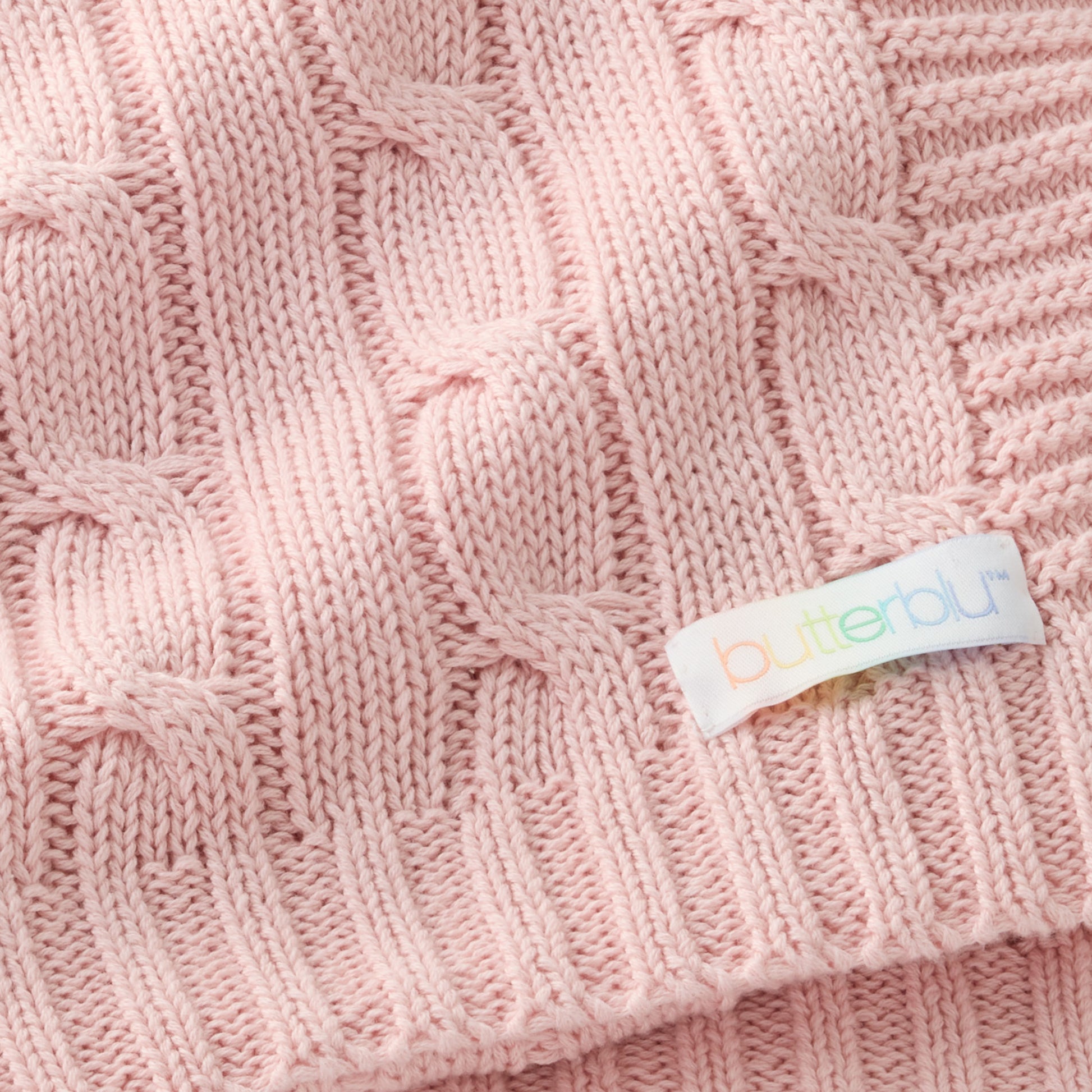 Close-up of a pink knitted fabric with a 'Butter' label.