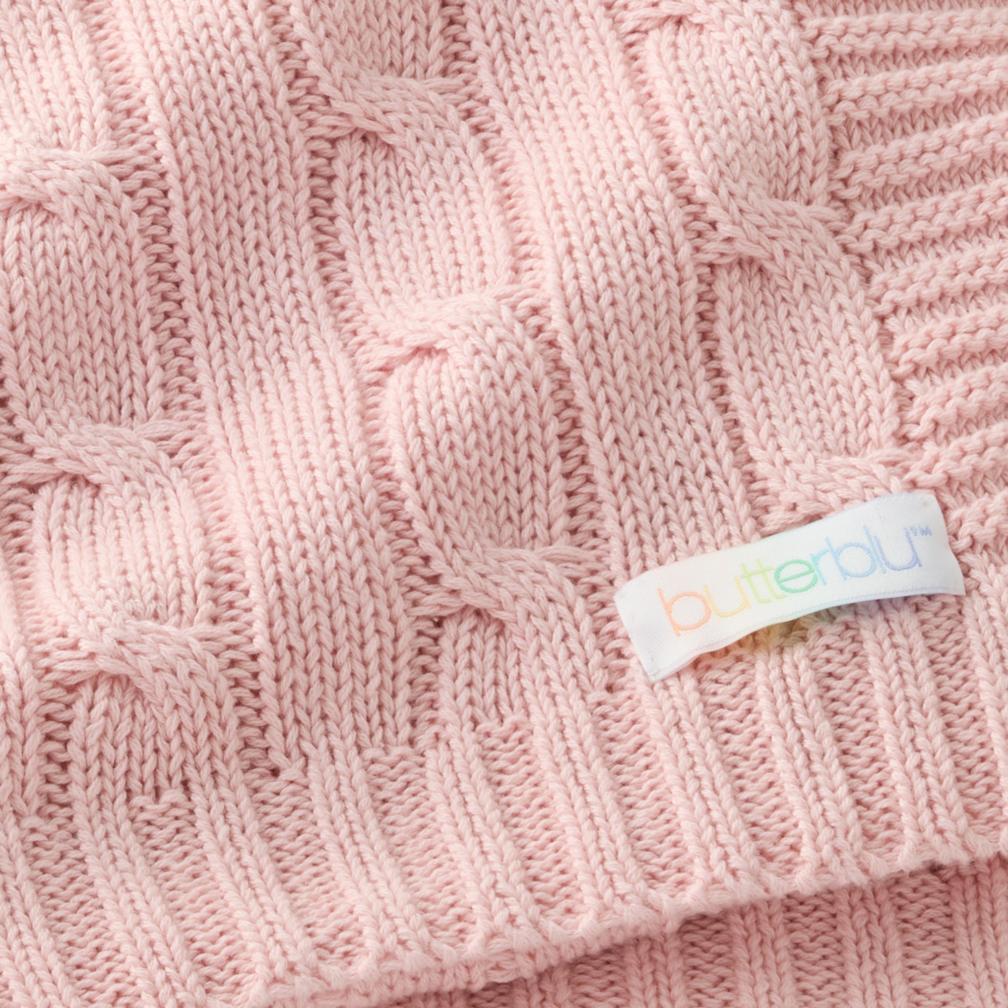 Close-up of a pink knitted fabric with a 'Butter' label.