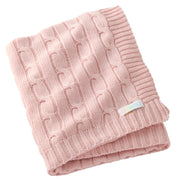 Pink knitted blanket with a visible brand label on a white background