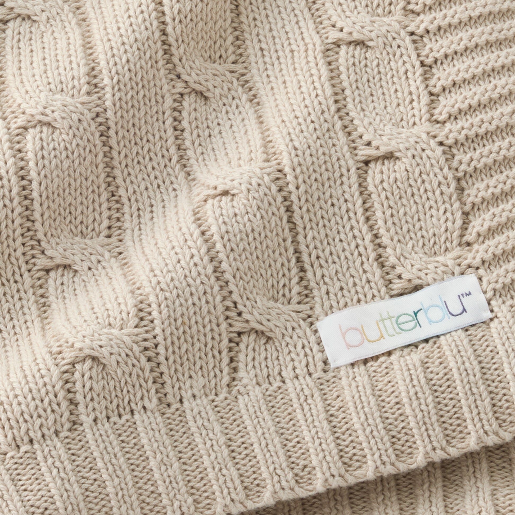 Close-up of a beige knitted fabric with a 'Cutterblu' label.