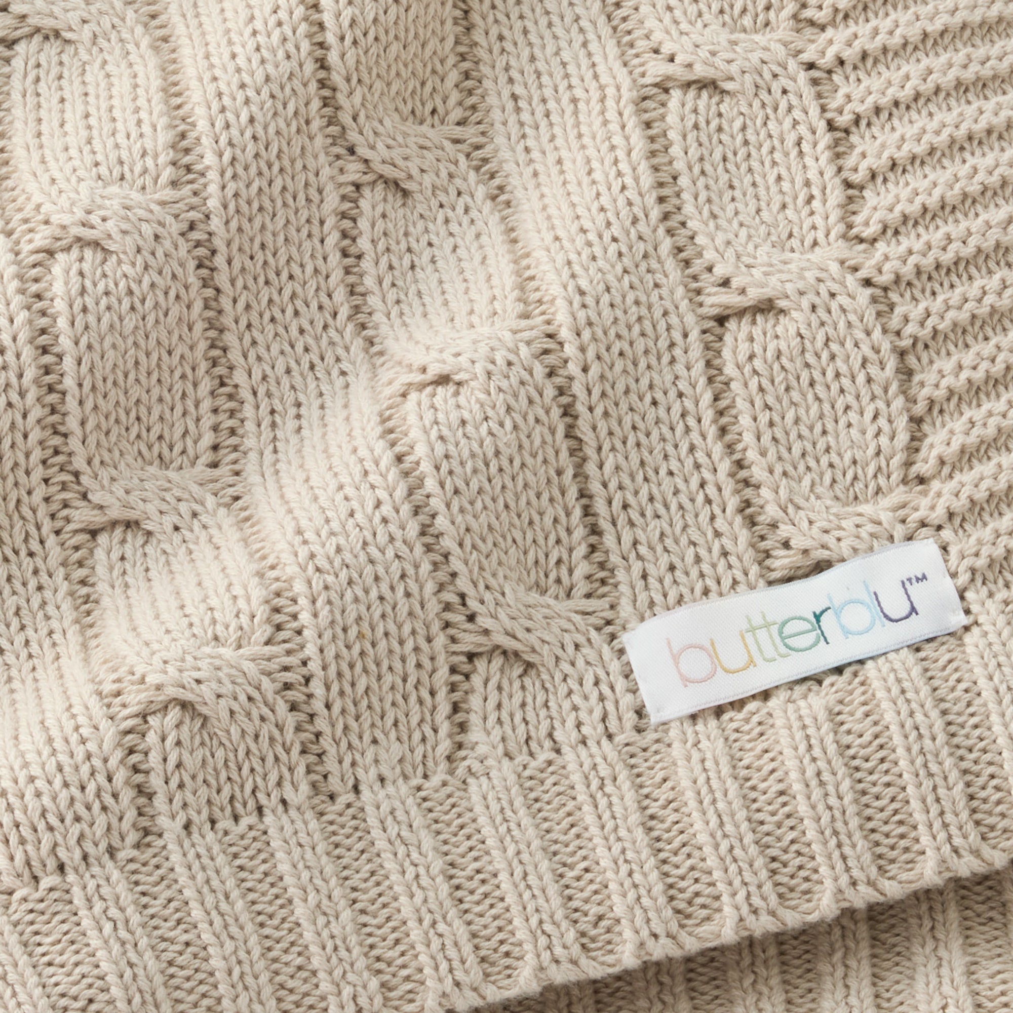 Close-up of a beige knitted fabric with a 'Cutterblu' label.