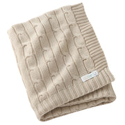 Folded beige knitted blanket with a brand label on a white background